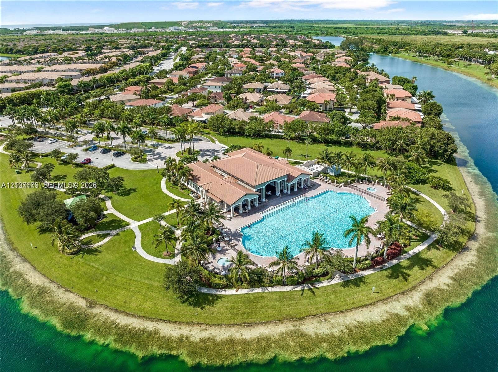 22066 SW 93rd Place, Cutler Bay, FL 33190 Waterfront community facility featuring a swimming pool, spa, paved walking paths, manicured landscaping, and a multi-purpose building with a tile roof