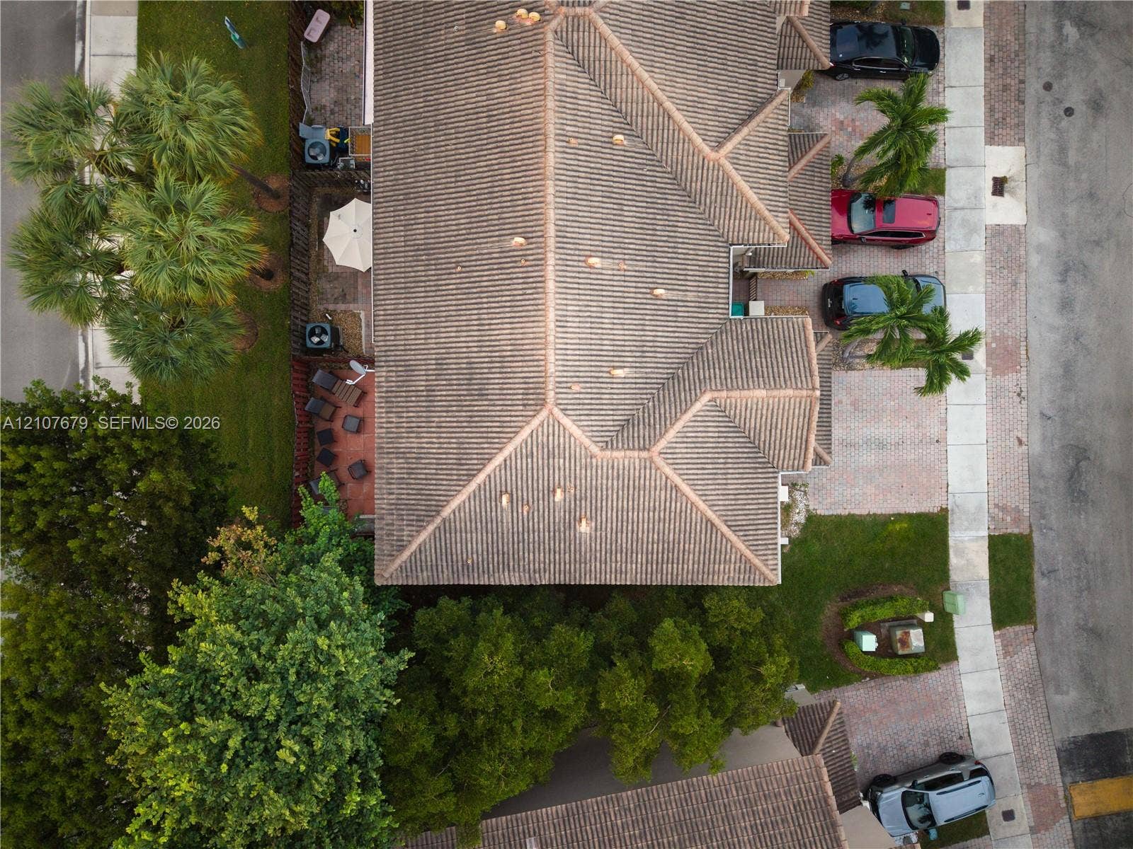 22066 SW 93rd Place, Cutler Bay, FL 33190 Aerial perspective featuring a multi-hipped tile roof, paver driveway, and mature landscaping
