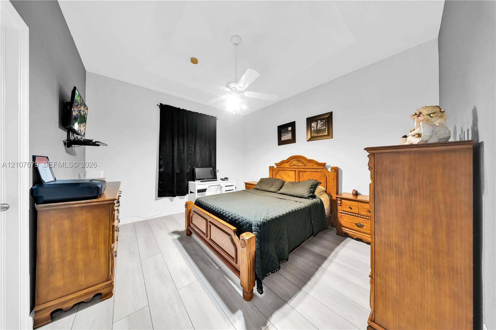 22066 SW 93rd Place, Cutler Bay, FL 33190 Room featuring tray ceiling, wood-finish flooring, and a ceiling fan with integrated lighting