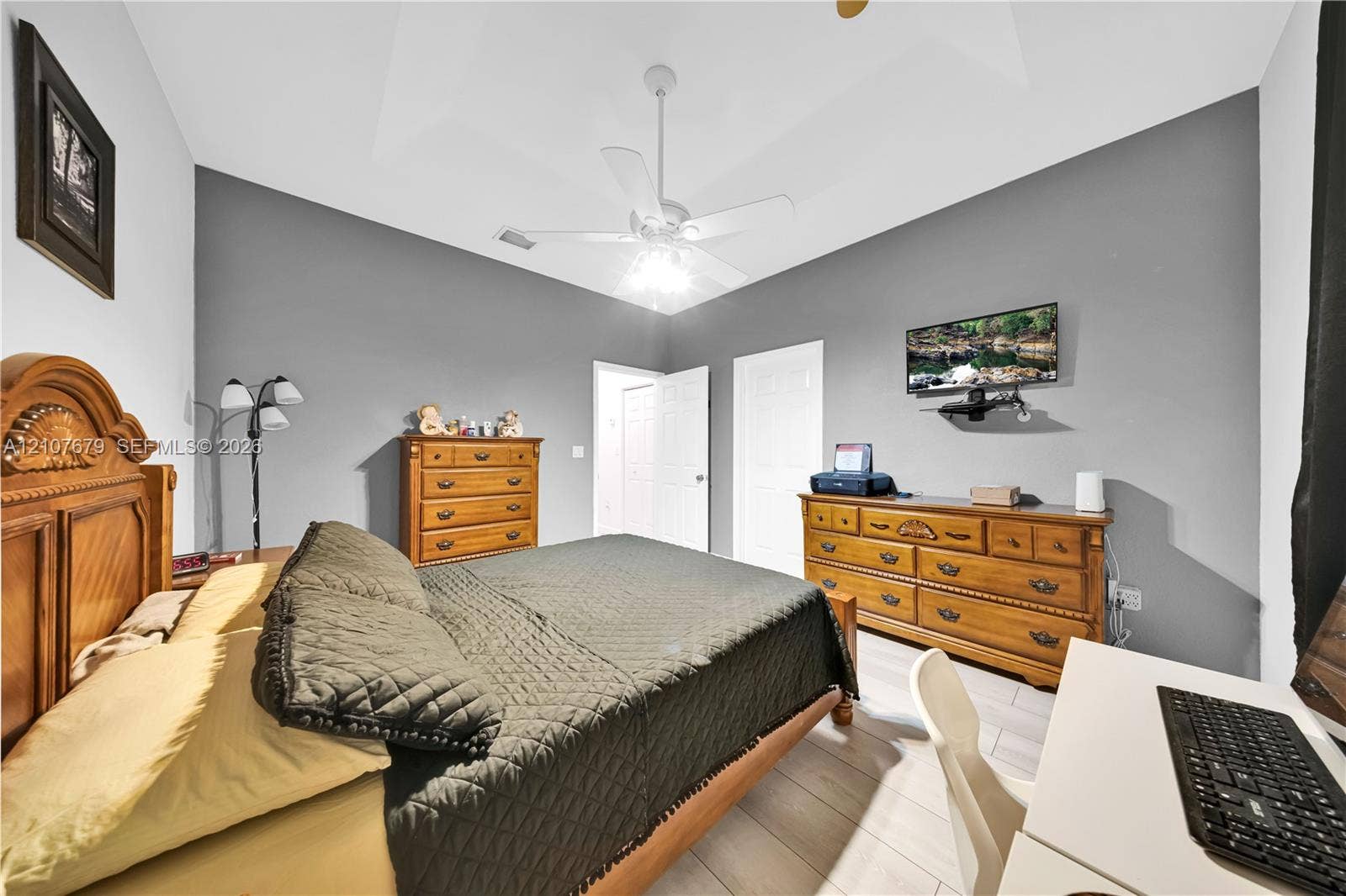 22066 SW 93rd Place, Cutler Bay, FL 33190 Vaulted ceiling featuring a central white ceiling fan with integrated lighting, paired with light-toned wood-finish flooring