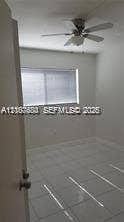 6310 SW 79th Street, #12, South Miami, South Miami, FL 33143 Neutral wall finishes, large-format tile flooring, window with horizontal blinds, and ceiling-mounted fan