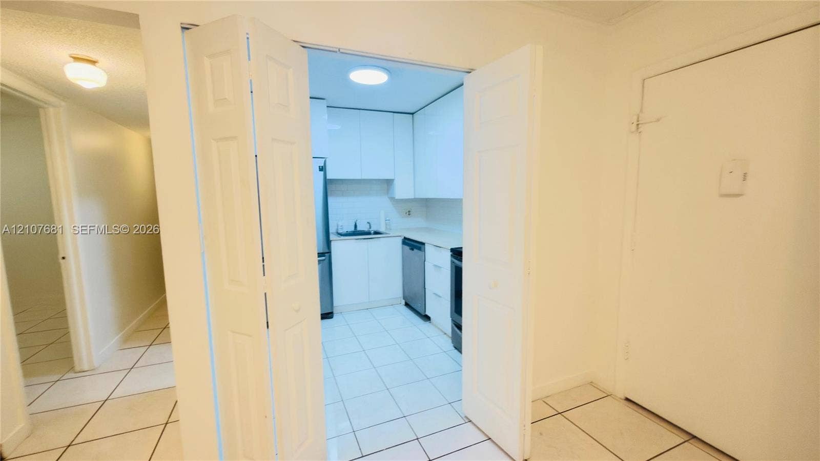 701 NE 1st Court, #202, Hallandale Beach, Hallandale Beach, FL 33009 Kitchen featuring flat-panel white cabinetry, stainless steel appliances, neutral countertops, and ceramic tile flooring