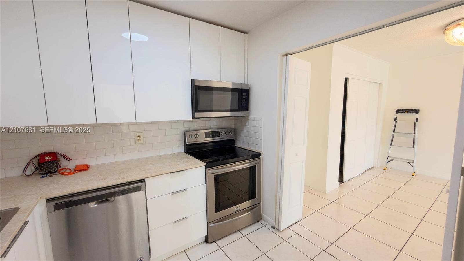 701 NE 1st Court, #202, Hallandale Beach, Hallandale Beach, FL 33009 Kitchen featuring flat-panel white cabinetry, stainless steel appliances, subway tile backsplash, and light-toned countertops