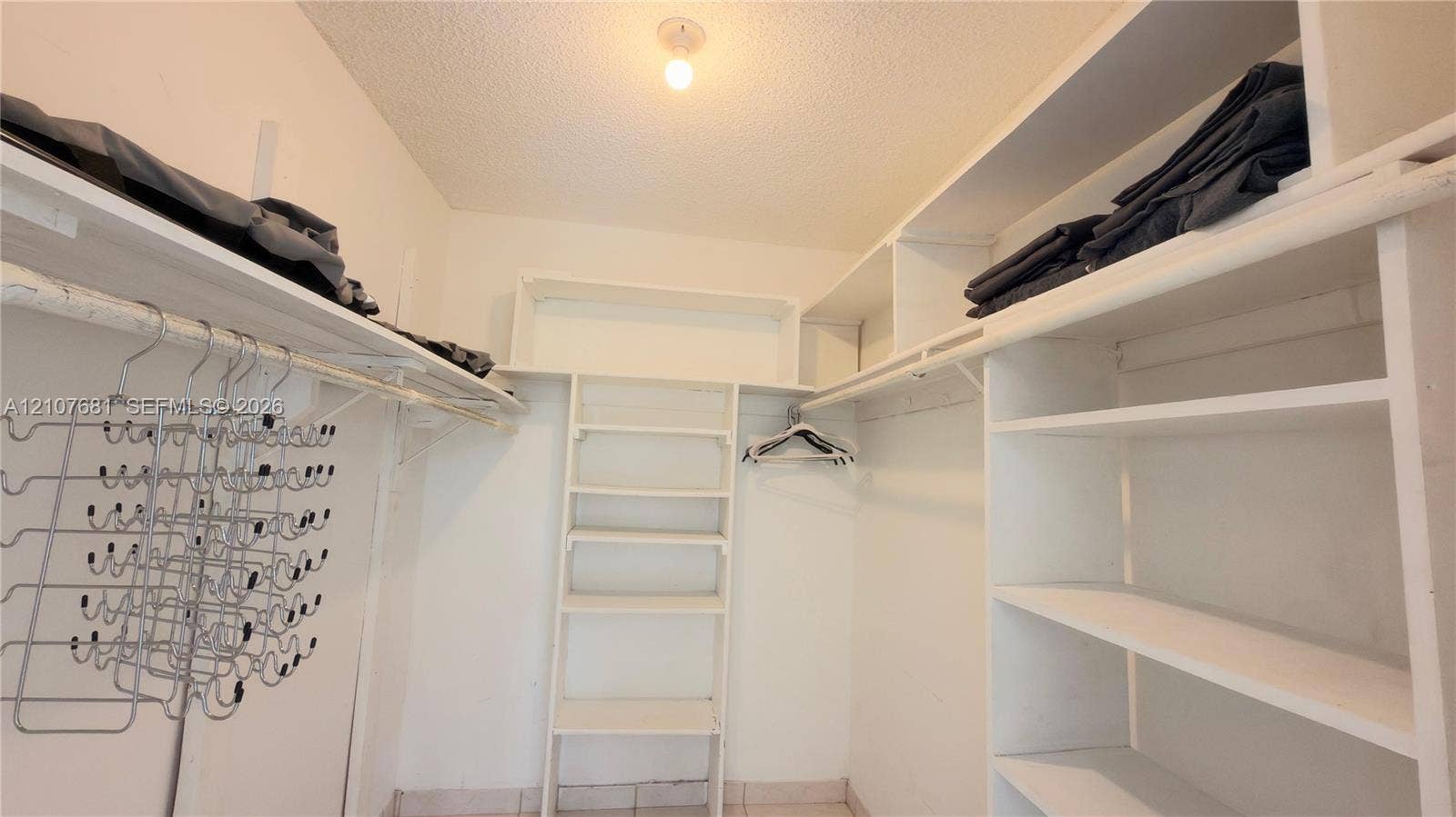 701 NE 1st Court, #202, Hallandale Beach, Hallandale Beach, FL 33009 Walk-in closet featuring white built-in shelving, overhead storage racks, integrated hanging rods, and tile flooring