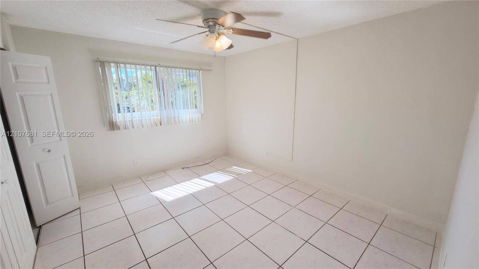 701 NE 1st Court, #202, Hallandale Beach, Hallandale Beach, FL 33009 Neutral-toned room featuring tile flooring, a multi-blade ceiling fan with integrated lighting, and vertical window blinds