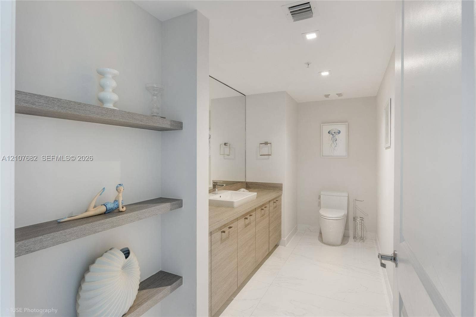 400 Sunny Isles Boulevard, #704, Sunny Isles Beach, Sunny Isles Beach, FL 33160 Bathroom featuring built-in wood-finish shelving, vanity with a rectangular vessel sink, large wall-mounted mirror, recessed ceiling lighting, and large-format tile flooring