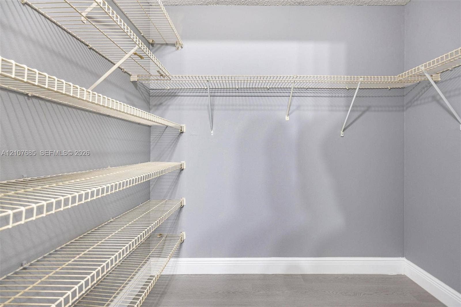 1460 Jefferson Drive, #1460L, Homestead, FL 33034 Walk-in storage space featuring multi-tiered white wire shelving, neutral-toned walls, and wood-finish flooring