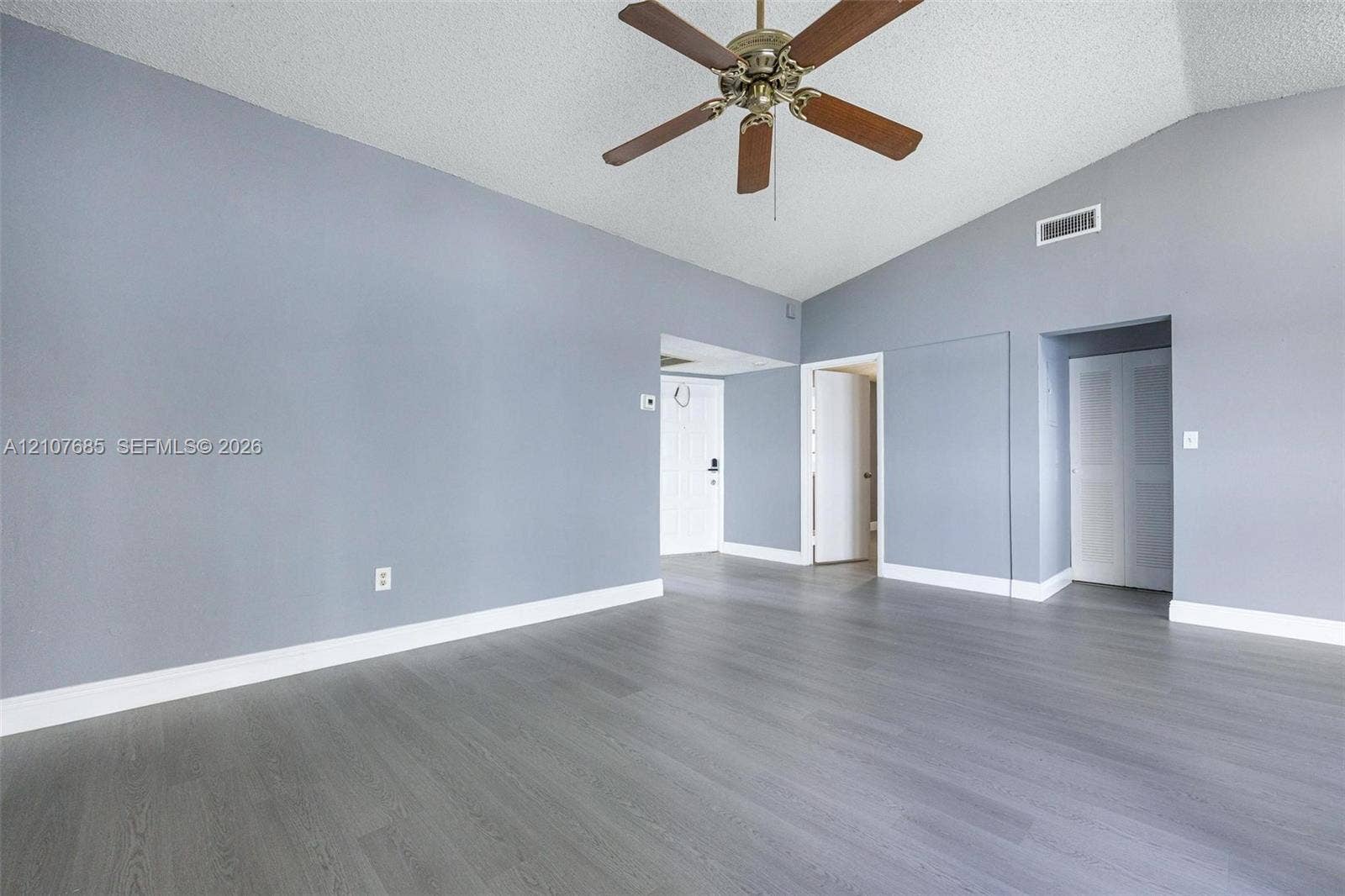 1460 Jefferson Drive, #1460L, Homestead, FL 33034 Room featuring vaulted ceilings, wood-finish flooring, and a ceiling fan with integrated lighting