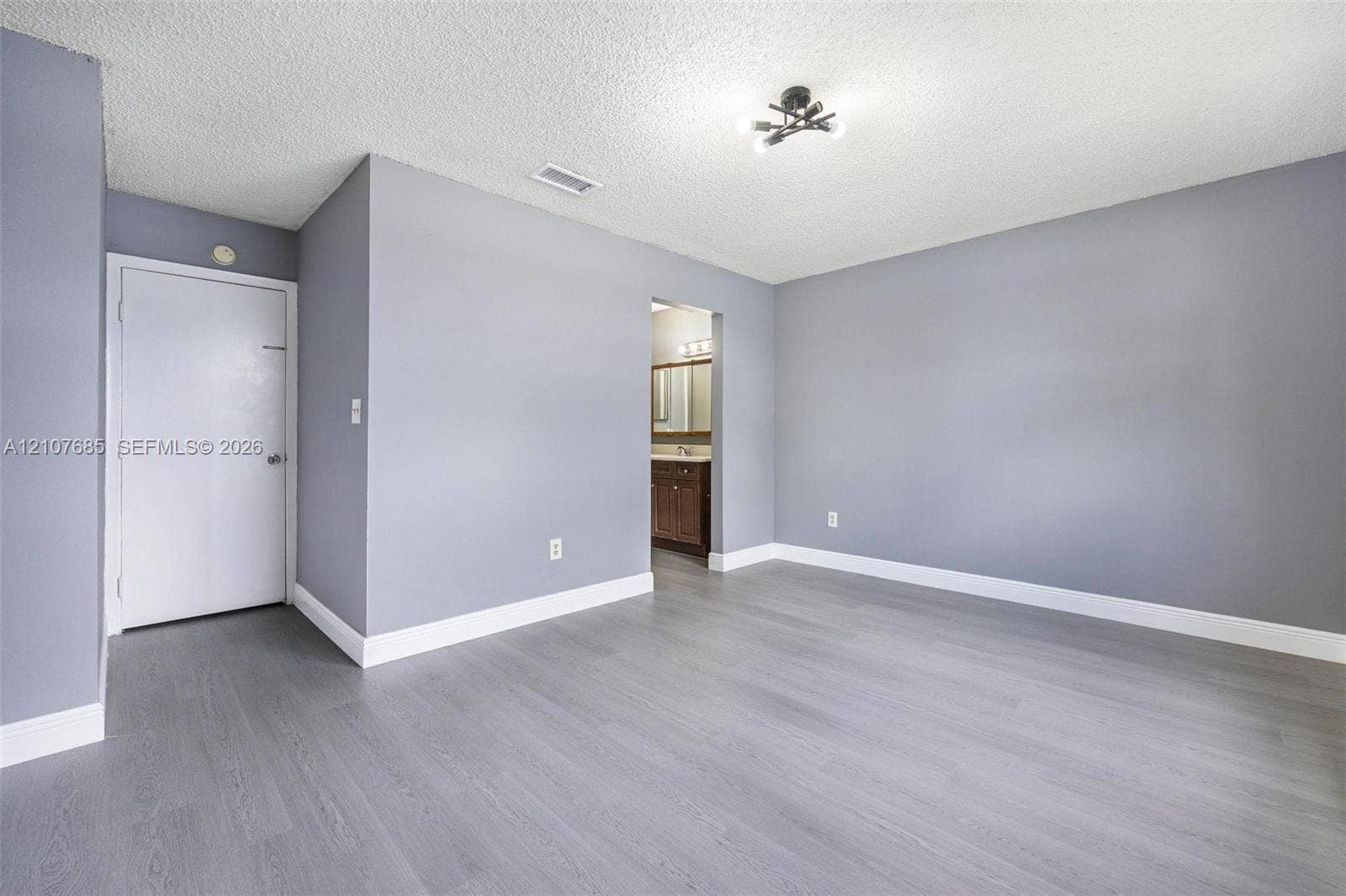 1460 Jefferson Drive, #1460L, Homestead, FL 33034 Room featuring wood-finish flooring, neutral gray wall paint, and multi-light flush mount ceiling fixture