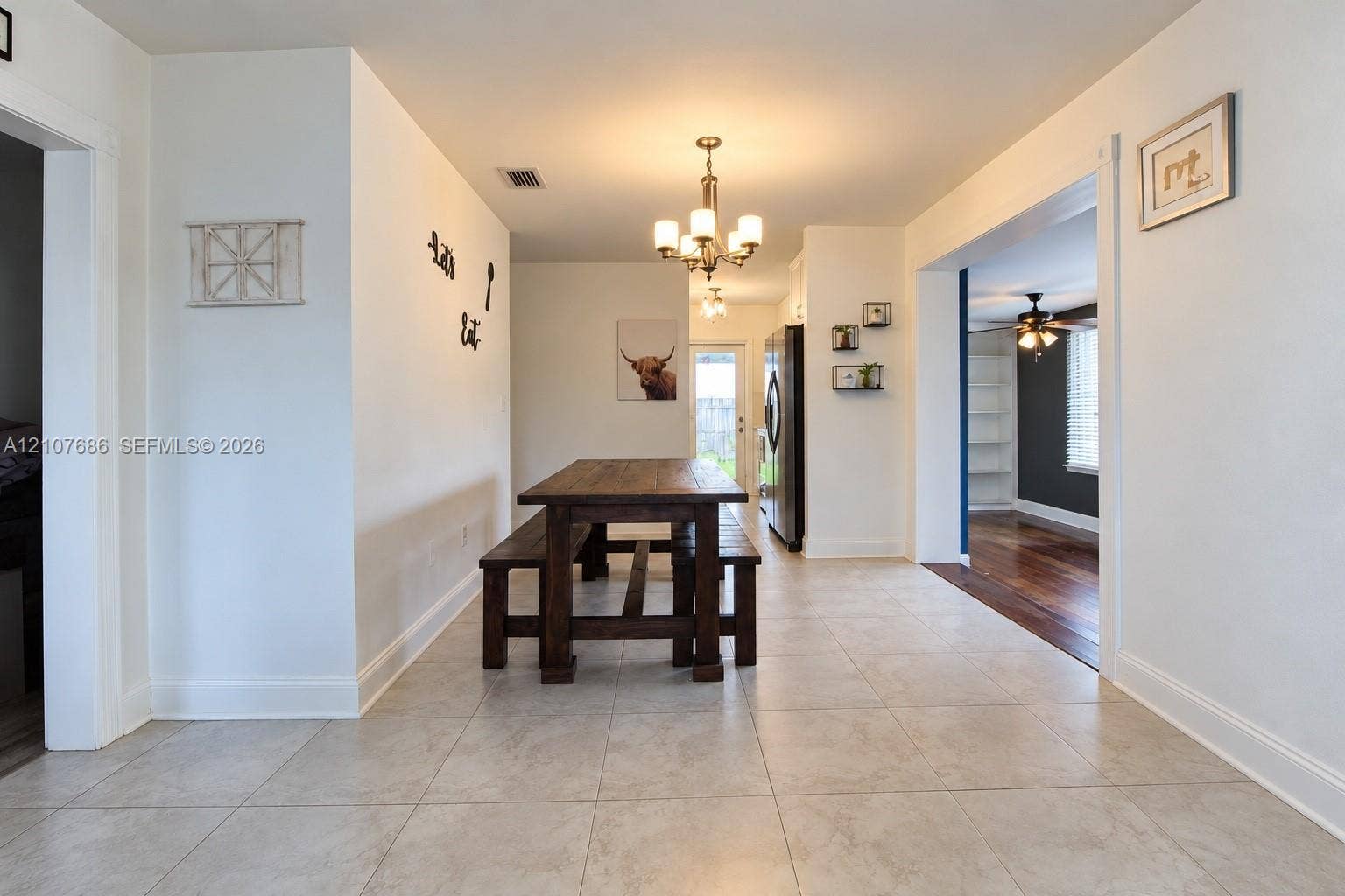 9760 Jamaica Drive, Cutler Bay, FL 33189 Dining area featuring light-toned tile flooring, a multi-arm chandelier, and a brushed stainless steel refrigerator