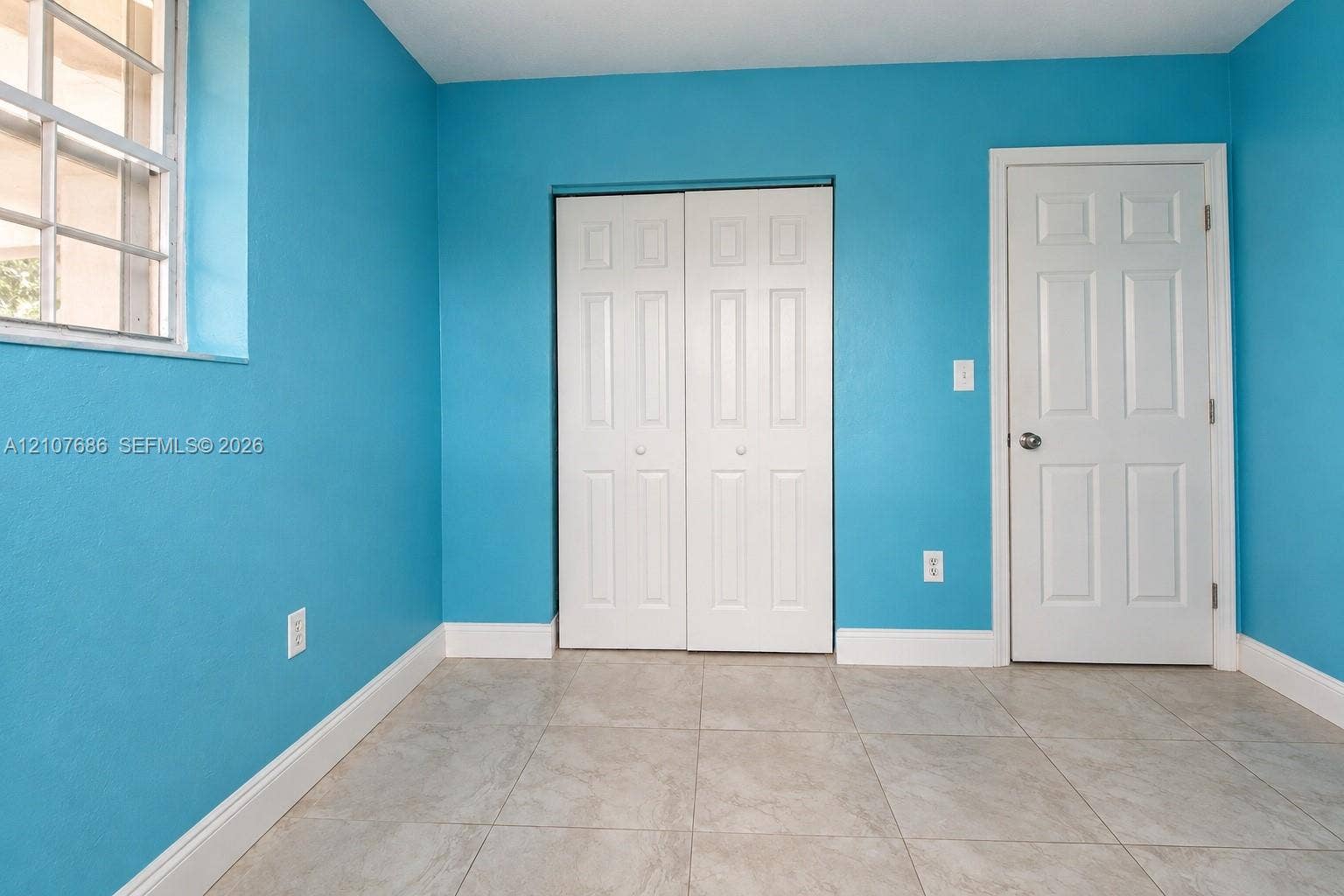 9760 Jamaica Drive, Cutler Bay, FL 33189 Interior room featuring tile flooring, a multi-pane window, and a white six-panel closet door