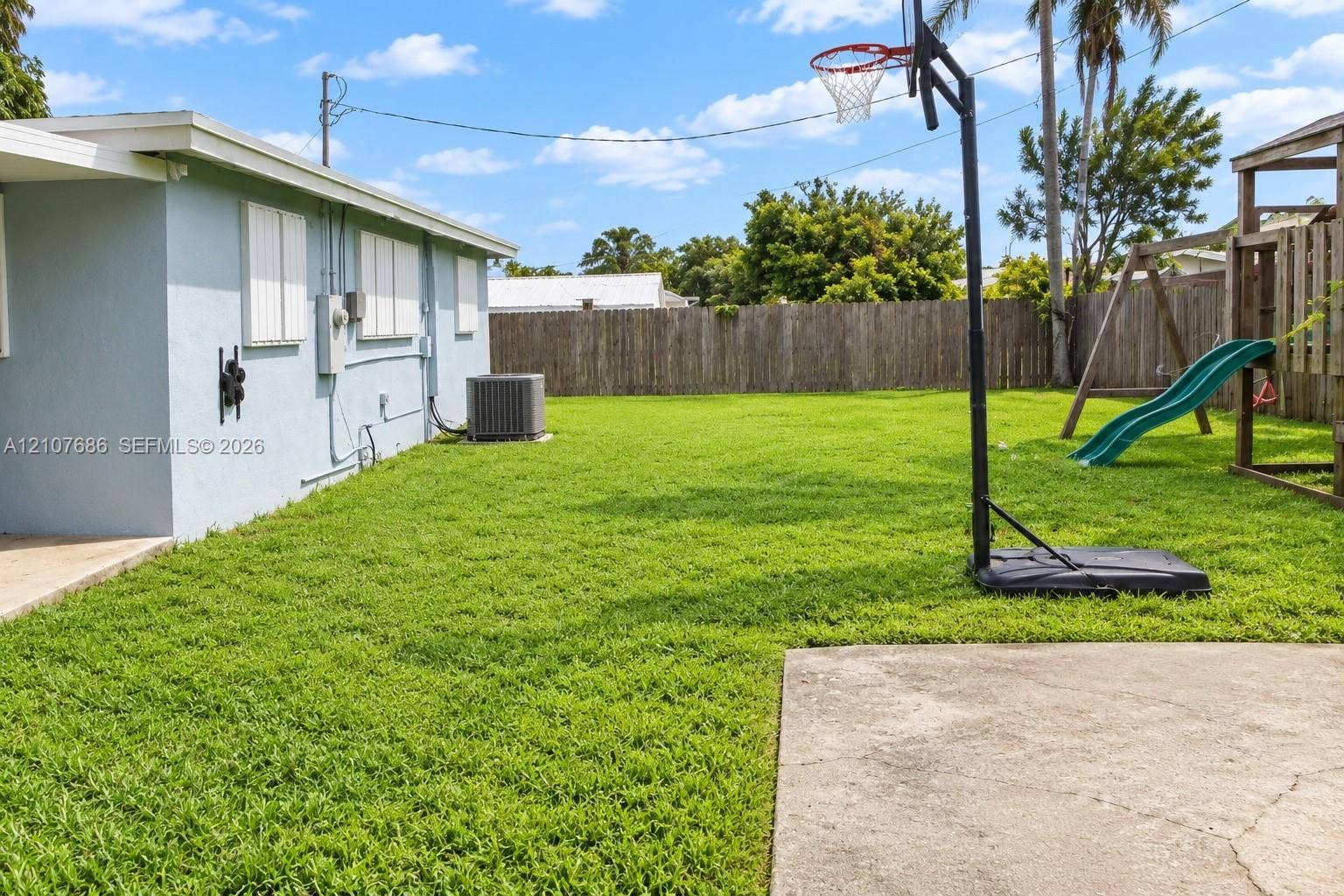 9760 Jamaica Drive, Cutler Bay, FL 33189 Expansive backyard featuring a level lawn, concrete patio, and full-height wood fencing