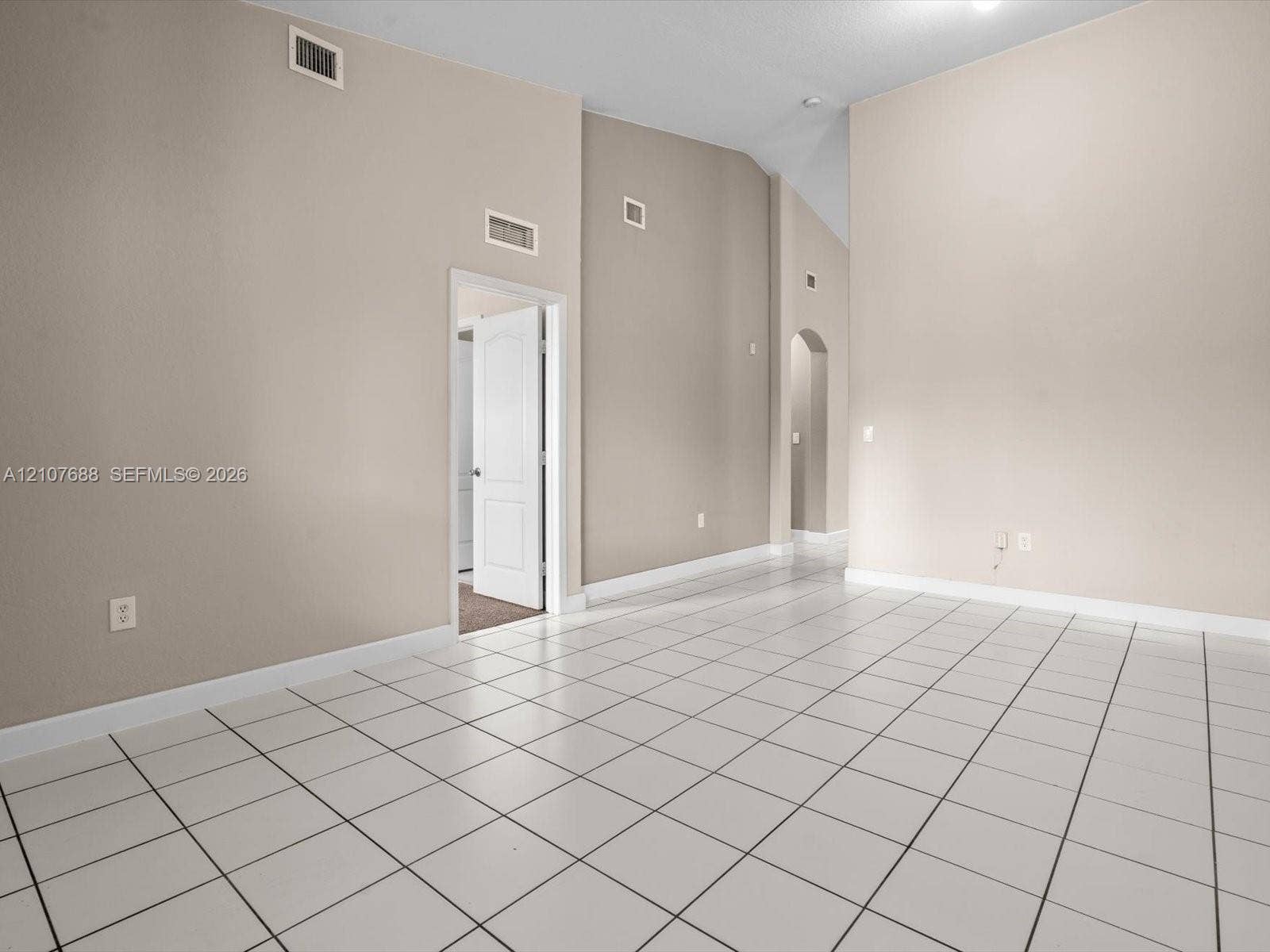1677 SE 27th Court, #202, Homestead, FL 33035 Vaulted ceilings, neutral wall tones, ceramic tile flooring, and an arched entryway