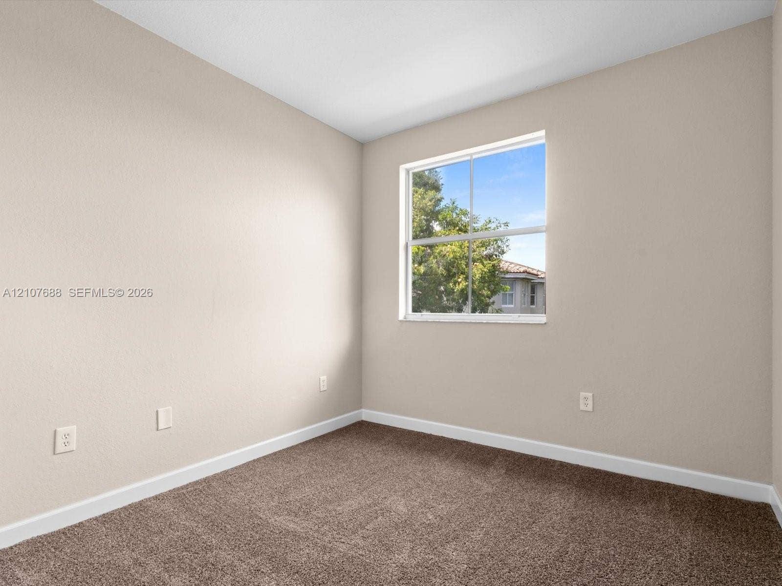 1677 SE 27th Court, #202, Homestead, FL 33035 Neutral-toned wall finish, wall-to-wall carpeting, and a single-pane window with natural exterior exposure