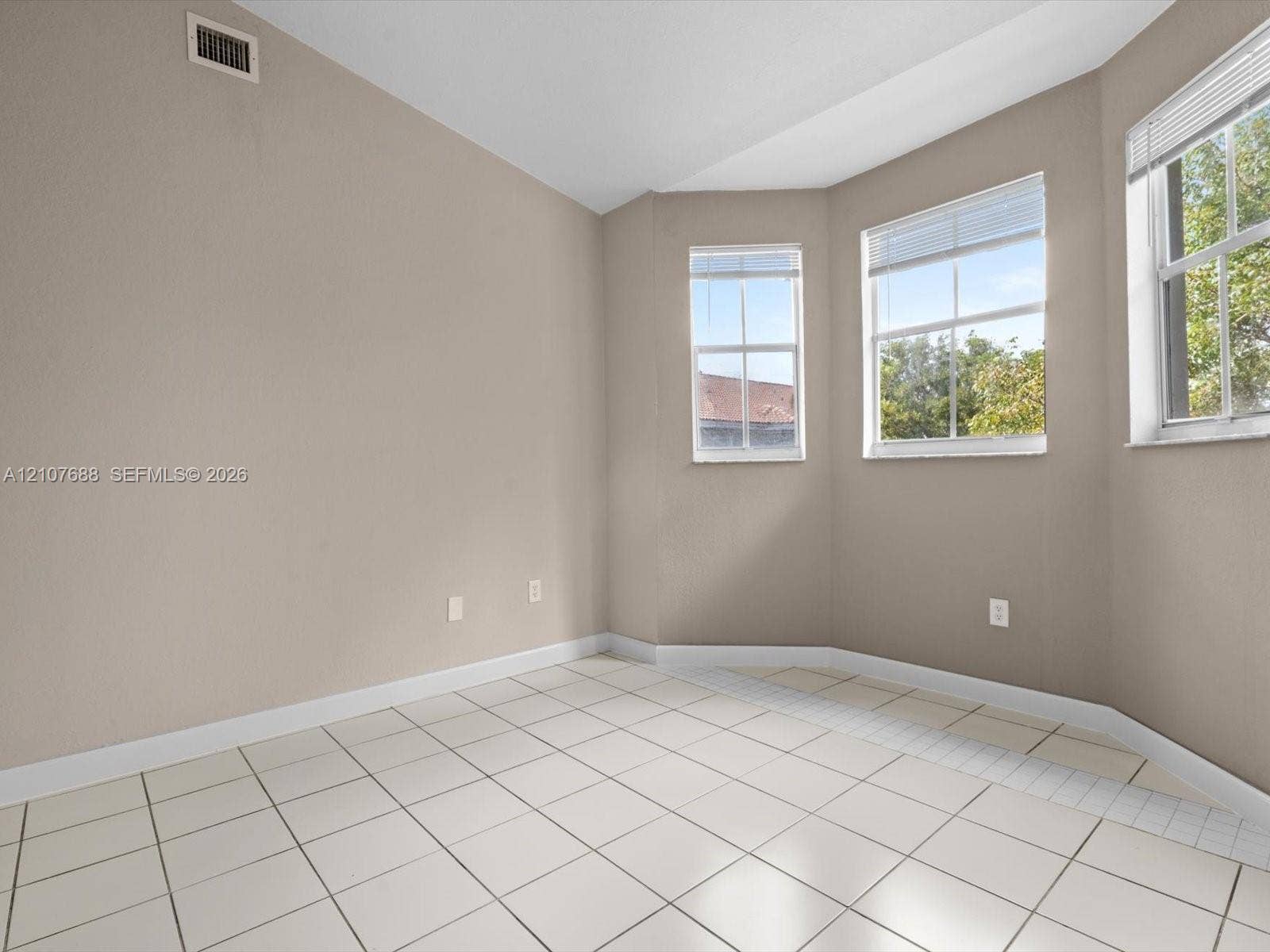 1677 SE 27th Court, #202, Homestead, FL 33035 Bay window featuring multi-pane glass windows, neutral wall paint, and ceramic tile flooring
