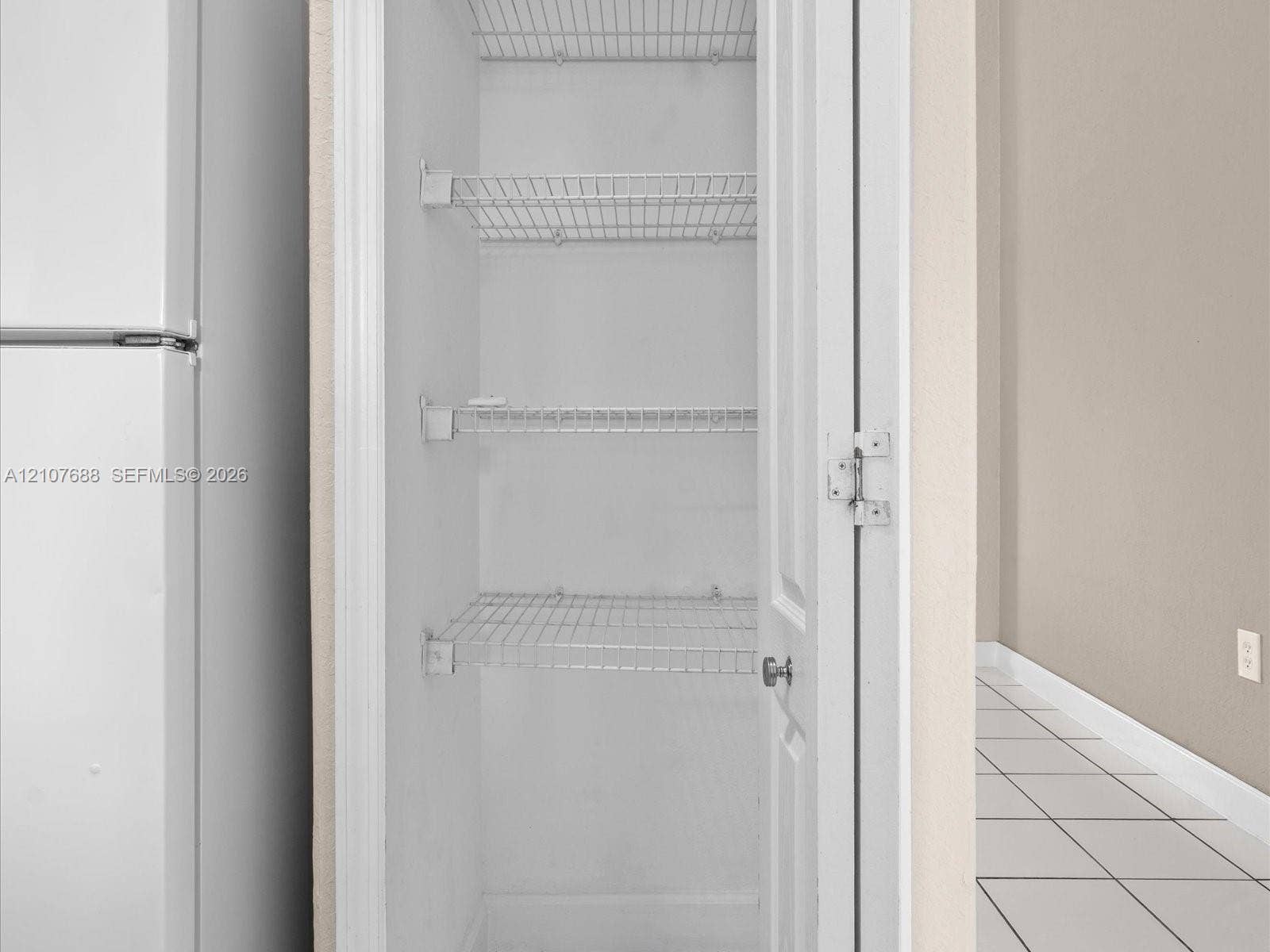 1677 SE 27th Court, #202, Homestead, FL 33035 Built-in storage closet featuring three-tier wire shelving and a paneled door