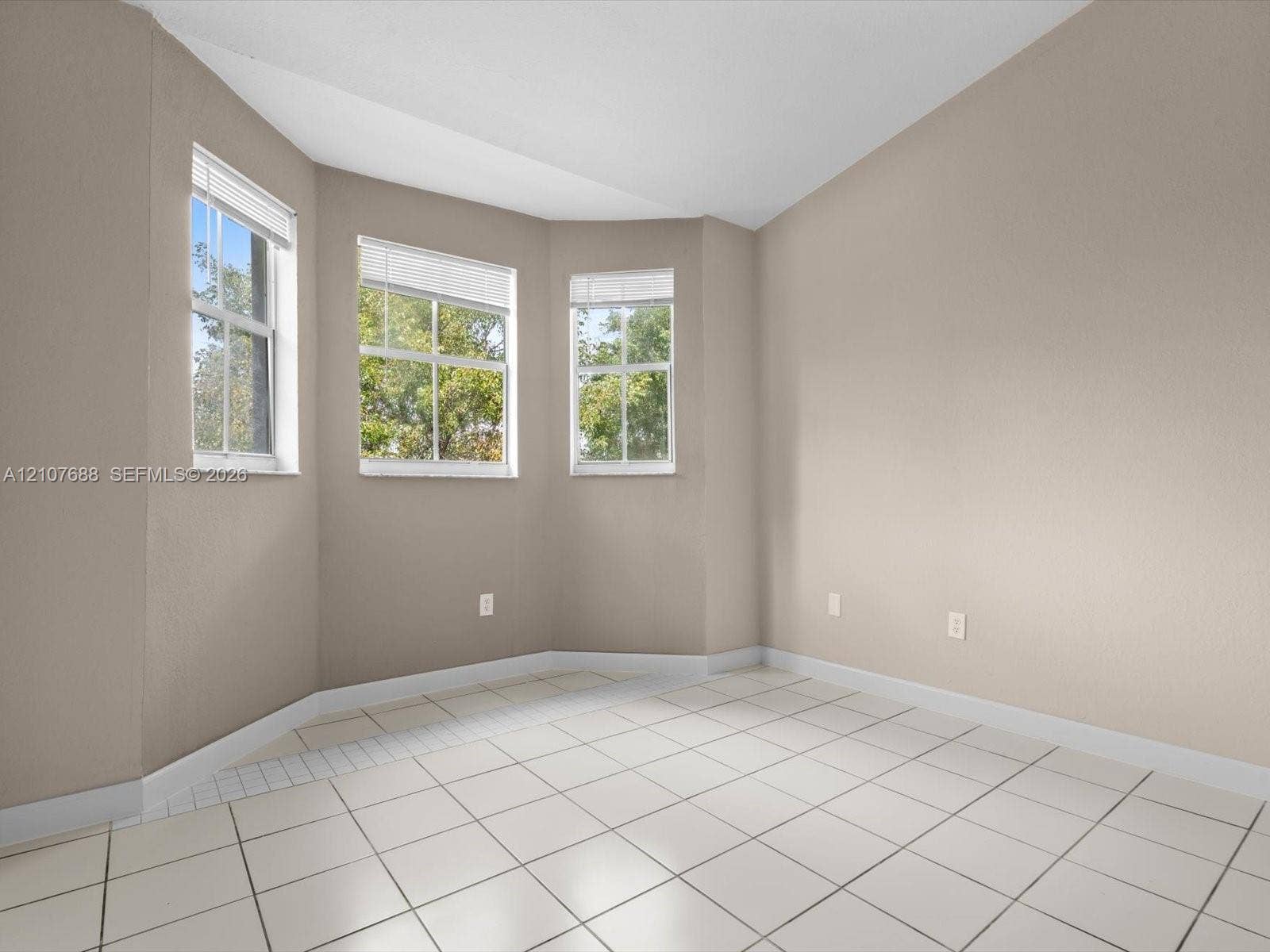 1677 SE 27th Court, #202, Homestead, FL 33035 Bay window featuring three paneled windows, neutral wall paint, and ceramic tile flooring