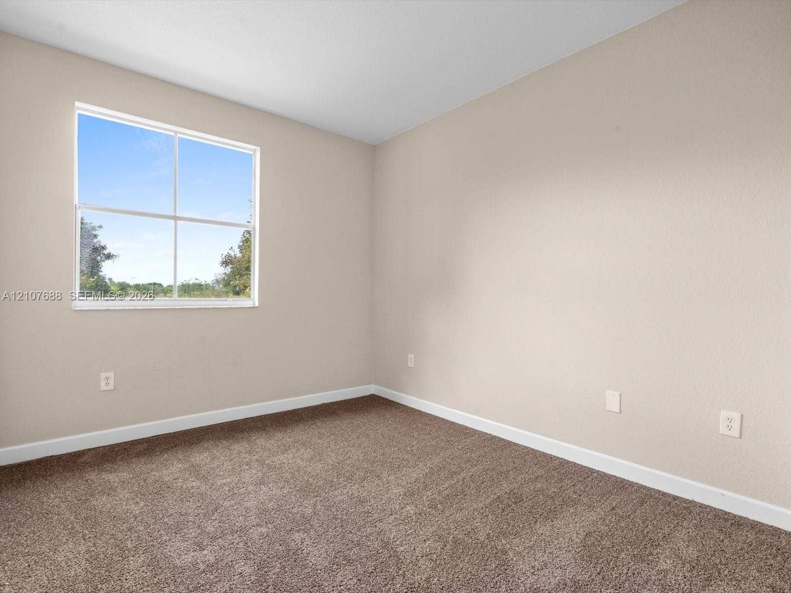 1677 SE 27th Court, #202, Homestead, FL 33035 Neutral interior room featuring neutral wall paint, carpeting, and a large grid-patterned window
