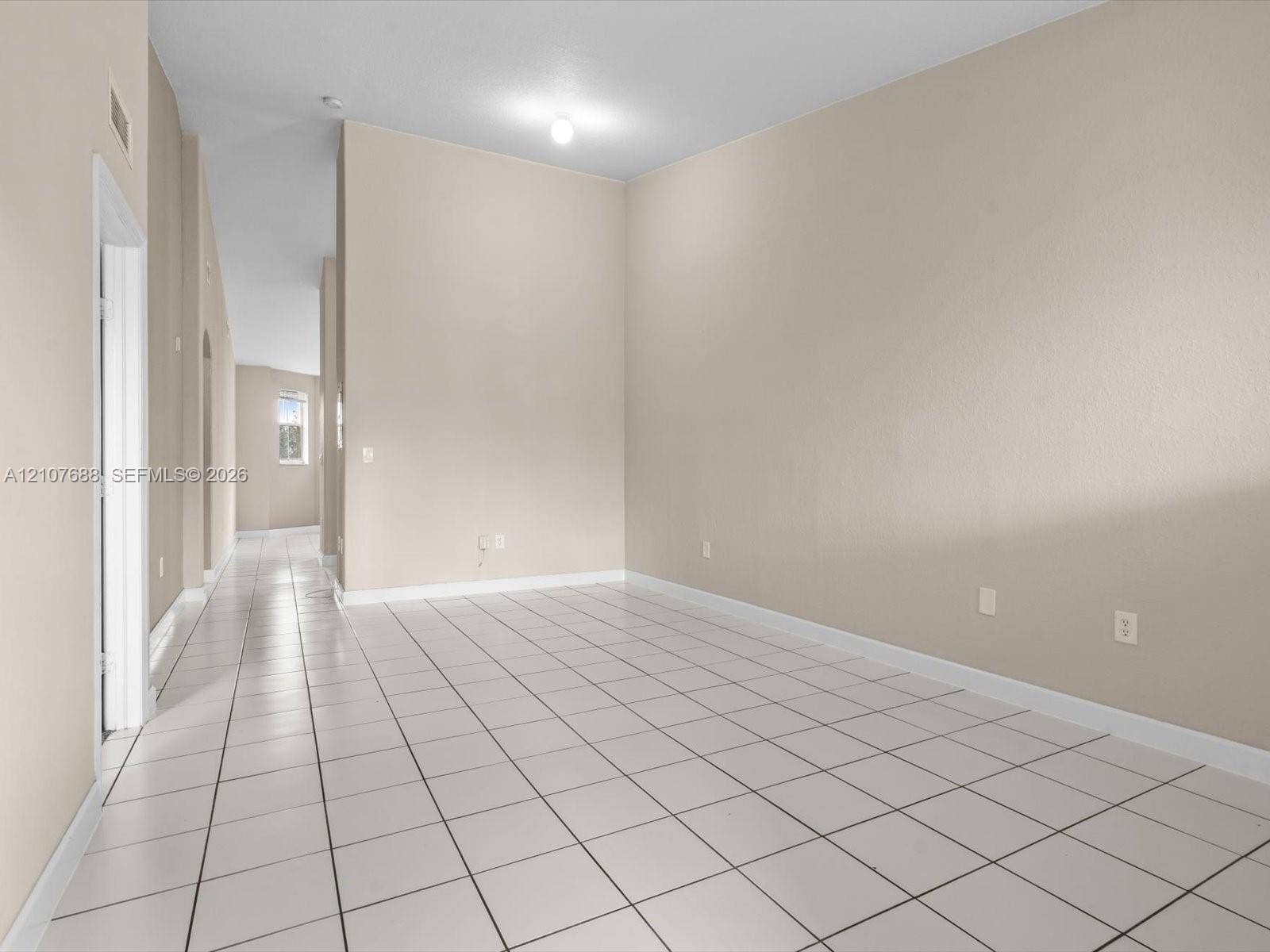 1677 SE 27th Court, #202, Homestead, FL 33035 Neutral-toned interior featuring high ceilings, white ceramic tile flooring, and a flush-mount ceiling fixture