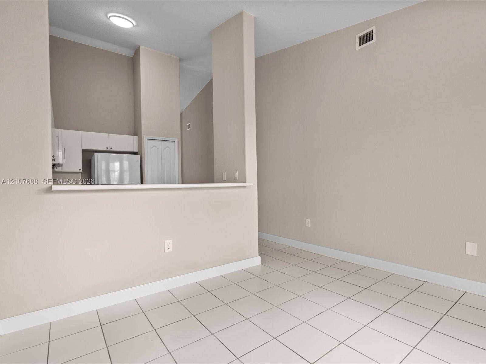 1677 SE 27th Court, #202, Homestead, FL 33035 Vaulted ceilings, neutral wall palette, ceramic tile flooring, and a kitchen pass-through counter