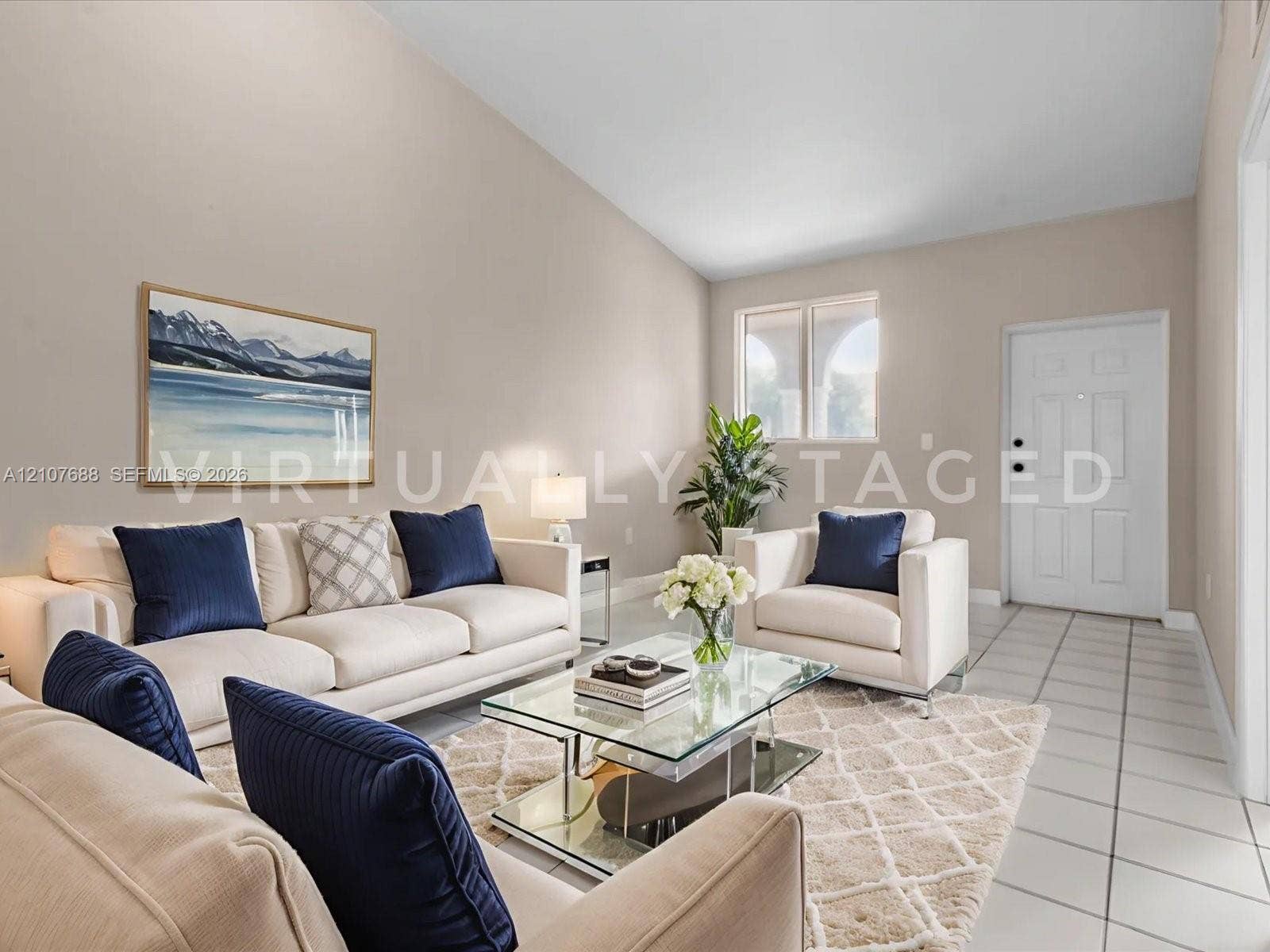 1677 SE 27th Court, #202, Homestead, FL 33035 Vaulted ceilings, neutral wall palette, ceramic tile flooring, and multi-pane window with arched architectural detail