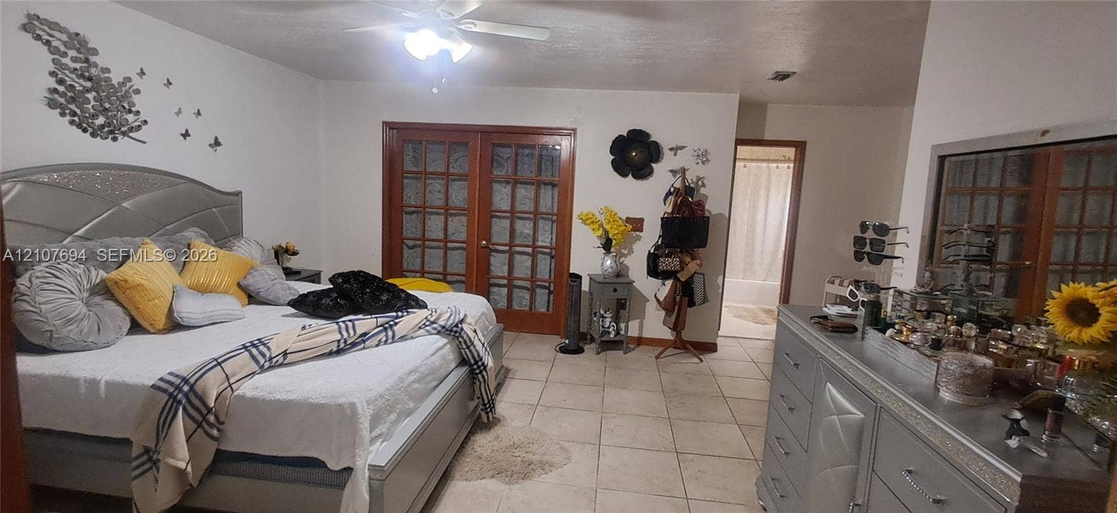 Ceramic tile flooring, French doors with glass panes, and a ceiling-mounted light fixture with a fan
