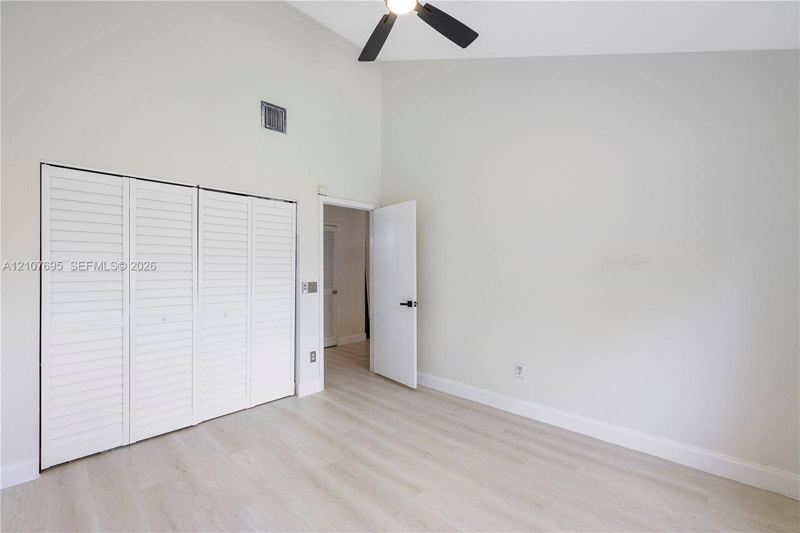 7198 Sportsmans Drive, North Lauderdale, FL 33068 Vaulted ceilings, wood-finish flooring, four-panel louvered closet doors, and a ceiling-mounted light fixture