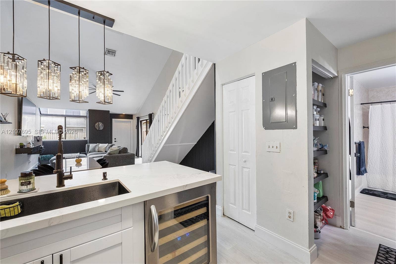 7198 Sportsmans Drive, North Lauderdale, FL 33068 Kitchen featuring a white countertop with an integrated undermount sink, matte black faucet, built-in wine refrigerator, glass pendant lighting, and recessed shelving