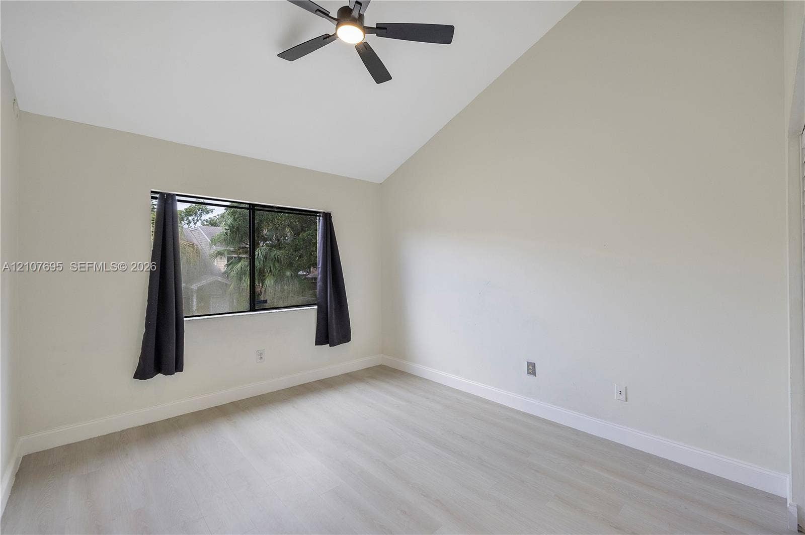 7198 Sportsmans Drive, North Lauderdale, FL 33068 Vaulted ceiling, light-tone wood-finish flooring, and matte black ceiling fan