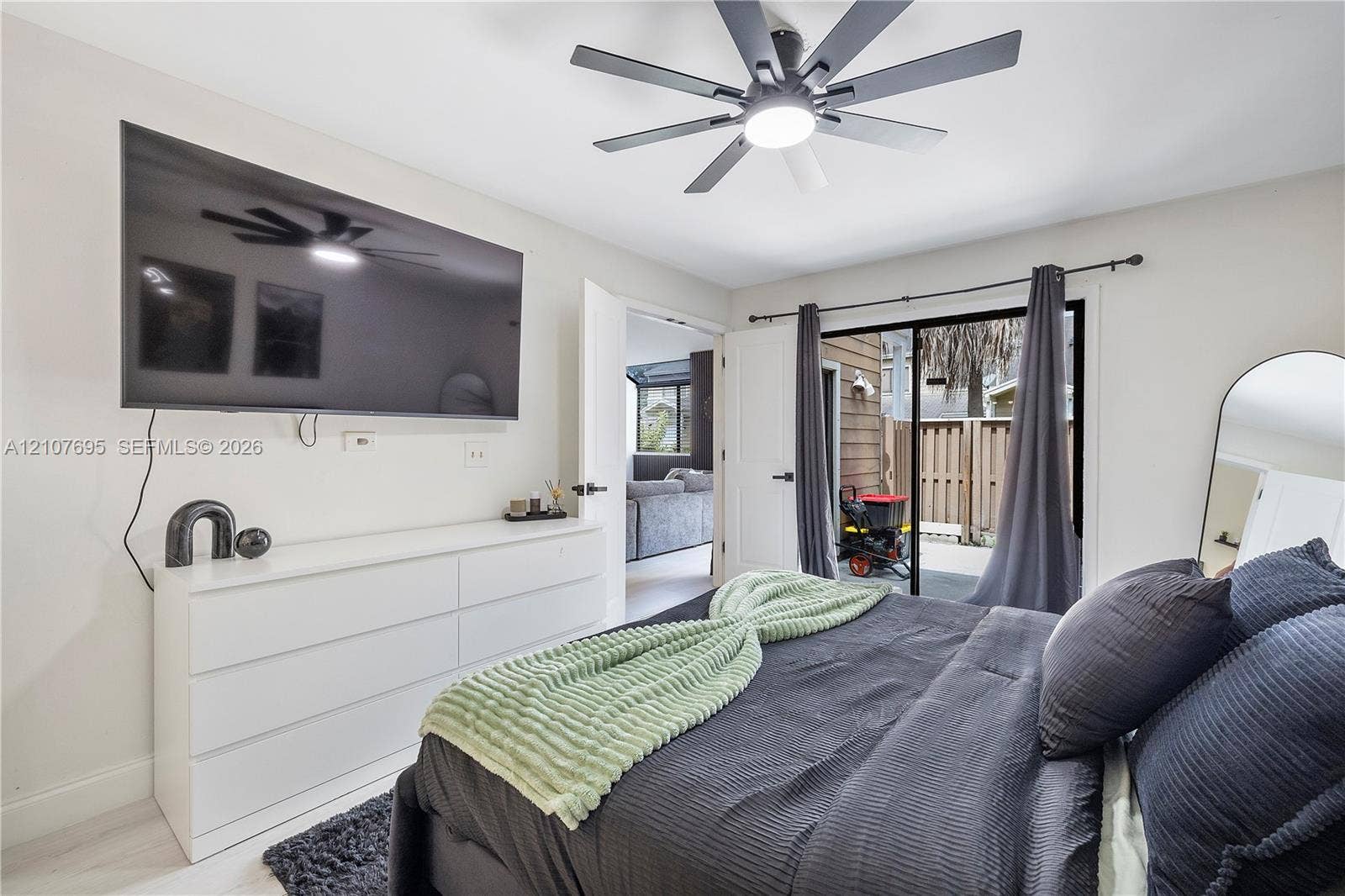 7198 Sportsmans Drive, North Lauderdale, FL 33068 Multi-blade ceiling fan with integrated lighting, sliding glass door with dark metal hardware, and neutral wall tones