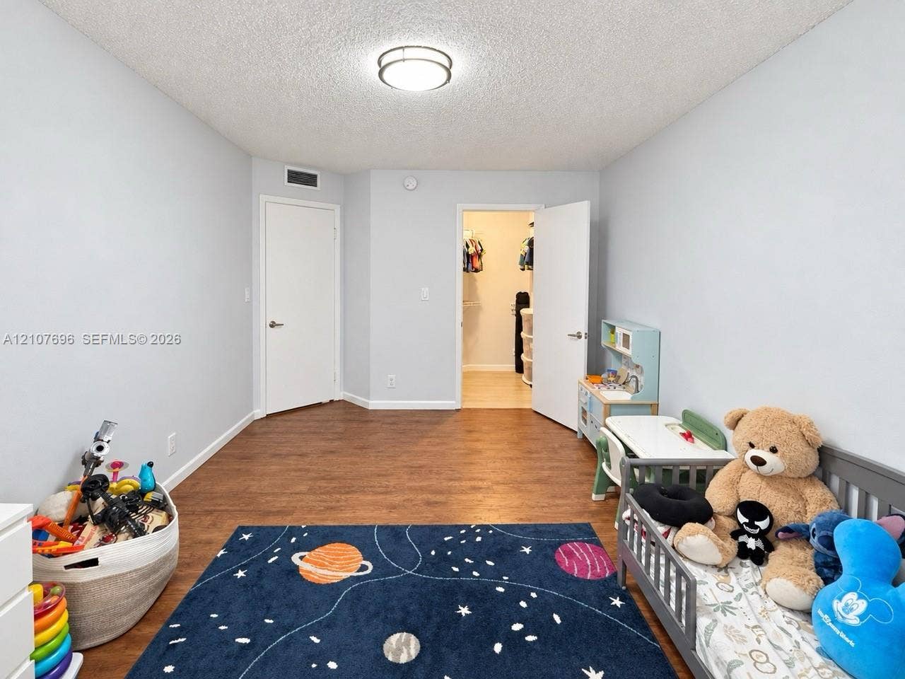 8290 Lake Drive, #418, Doral, FL 33166 Room featuring wood-finish flooring, a neutral color palette, a flush-mount ceiling light fixture, and an internal storage area with double doors