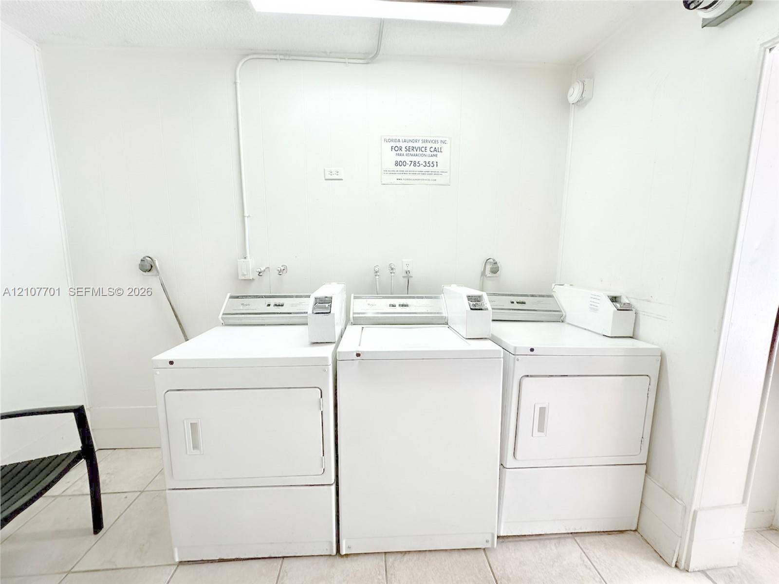 3100 Coral Springs Drive, #2B, Coral Springs, FL 33065 Laundry area featuring three white top-loading washers and light-toned tile flooring