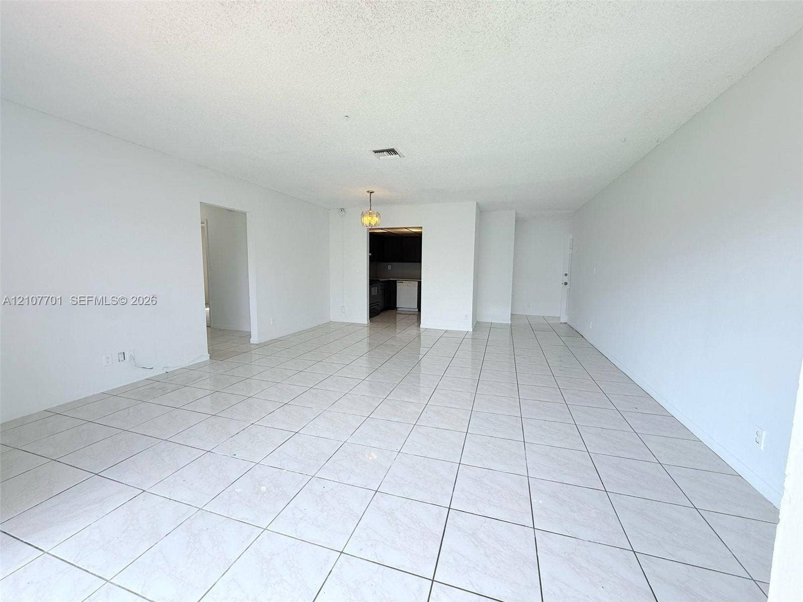 3100 Coral Springs Drive, #2B, Coral Springs, FL 33065 Open-concept floor plan featuring ceramic tile flooring, neutral wall tones, and overhead lighting fixtures