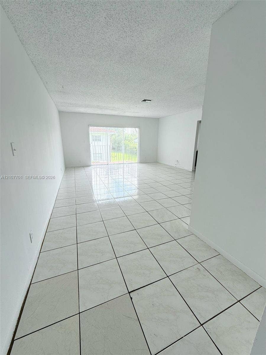 3100 Coral Springs Drive, #2B, Coral Springs, FL 33065 Open-concept interior featuring large-format tile flooring and sliding glass doors