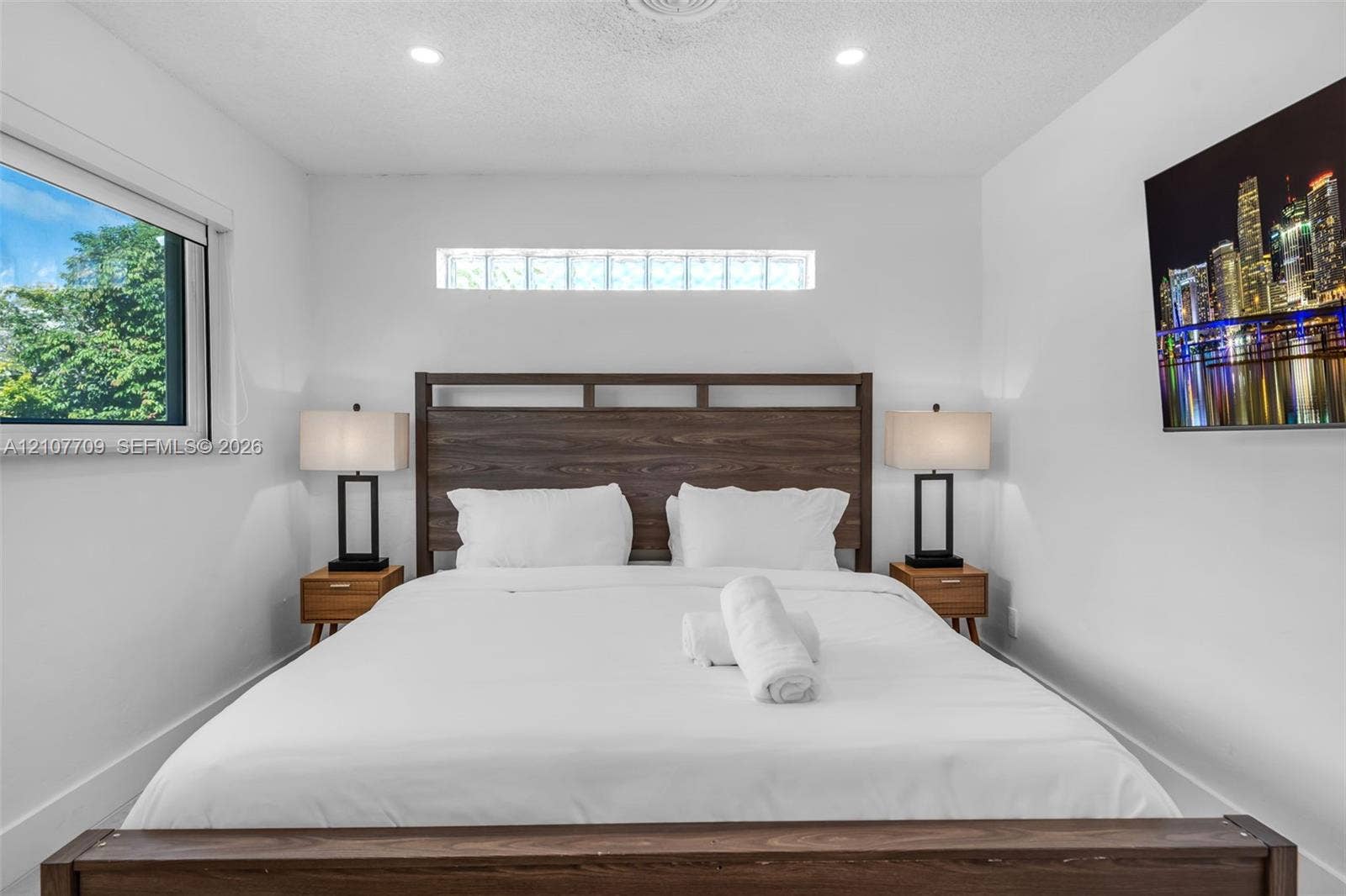 Neutral wall palette featuring recessed ceiling lighting, a horizontal glass block transom window, and a large rectangular window