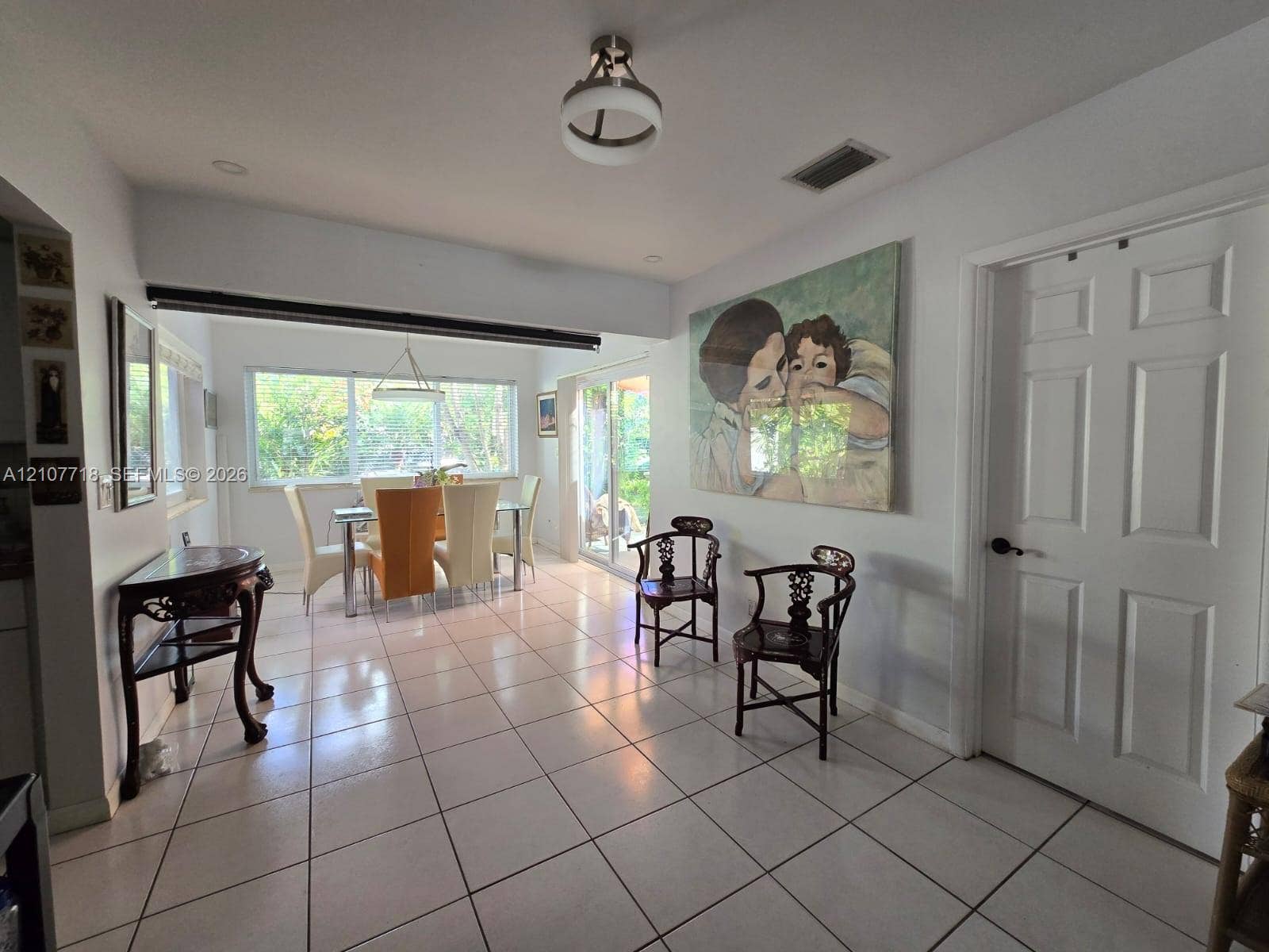 2321 N 57th Avenue, Hollywood, FL 33021 Interior space featuring tile flooring, neutral wall tones, six-panel interior door, multi-pane window, and decorative ceiling light fixture