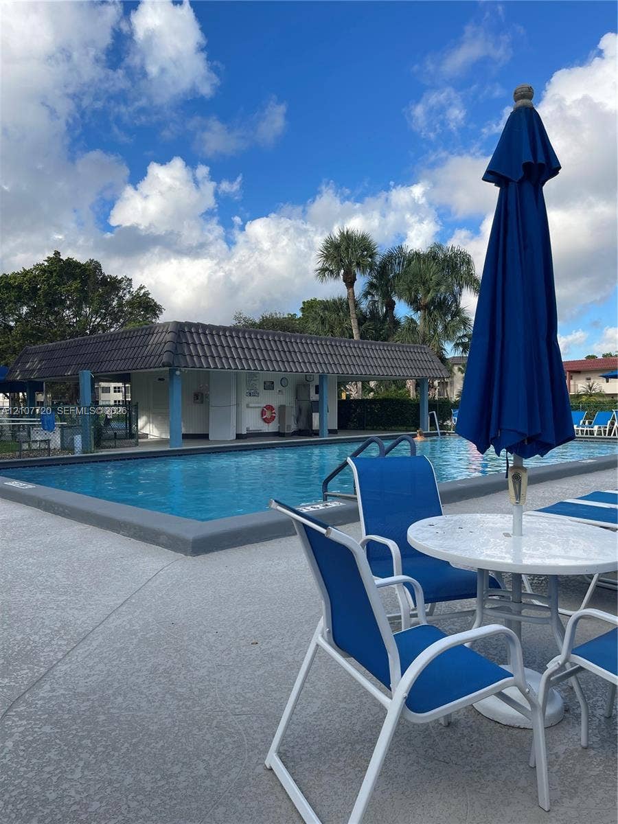 8921 S Hollybrook Boulevard, #204, Pembroke Pines, FL 33025 Outdoor swimming pool featuring a concrete deck and a covered pavilion with a tiled roof (more than 6 pool in the community)