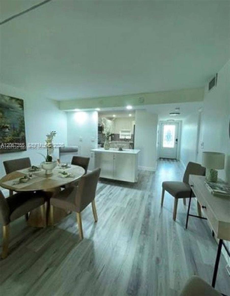 8921 S Hollybrook Boulevard, #204, Pembroke Pines, FL 33025 Open-concept interior featuring light wood-finish flooring, a central kitchen island with white cabinetry, and recessed lighting