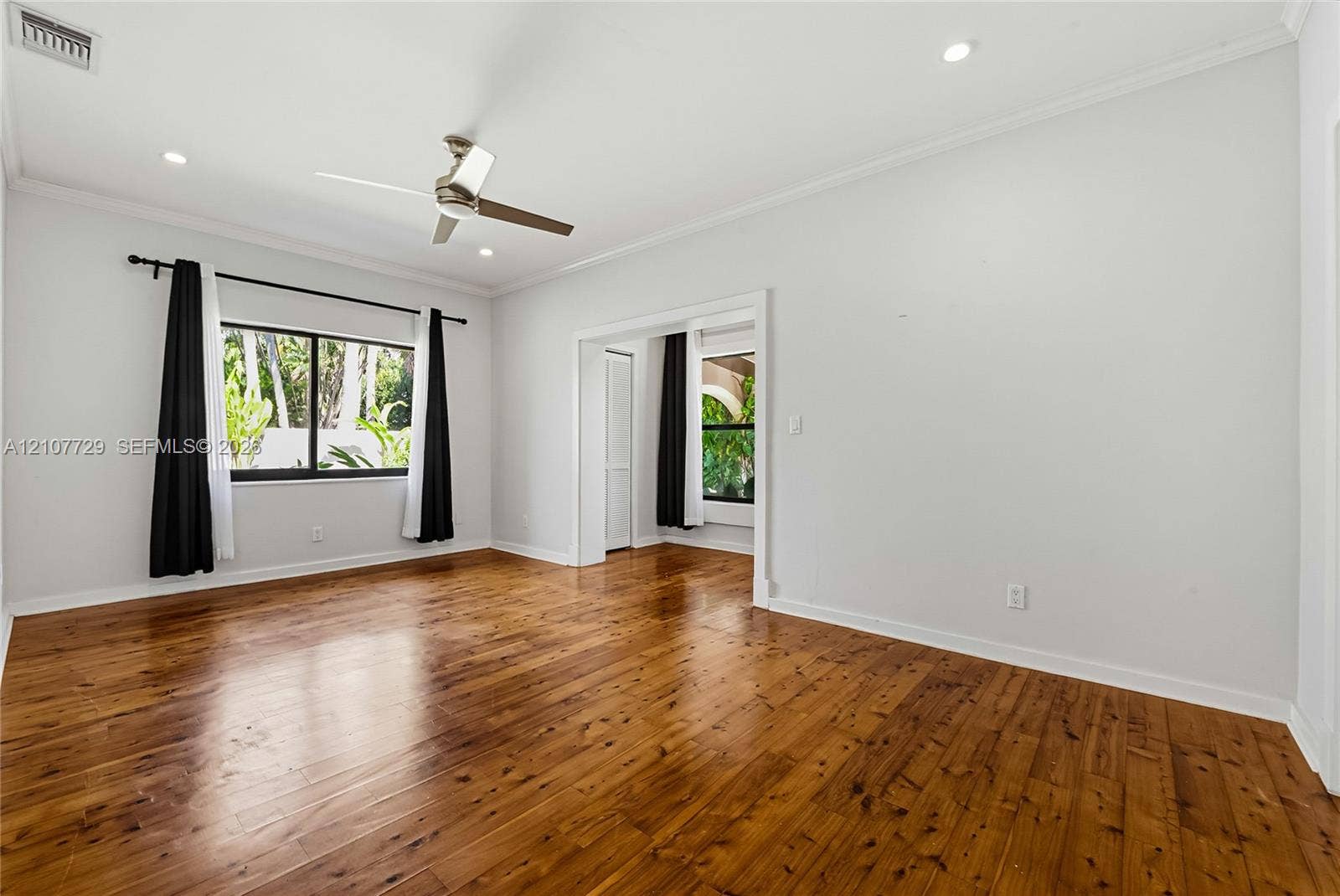 Room featuring wood-finish flooring, recessed lighting, and a multi-blade ceiling fan