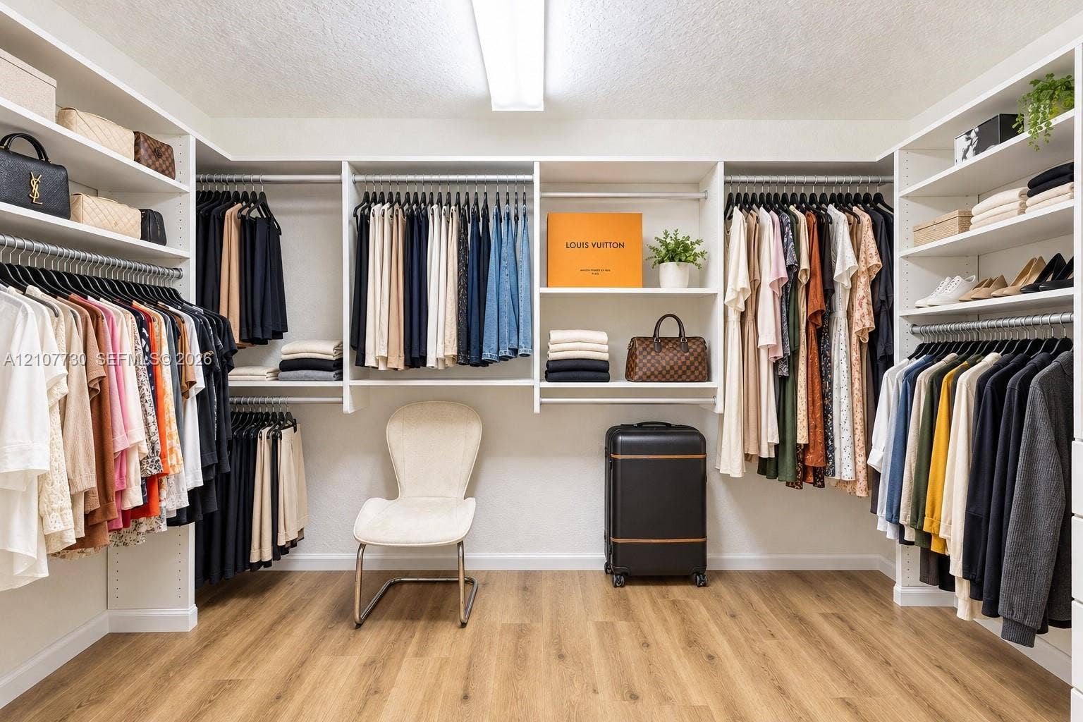15606 SW 52nd Court, Miramar, FL 33027 Custom walk-in closet featuring extensive built-in white shelving, multi-level hanging rods, and wood-finish flooring