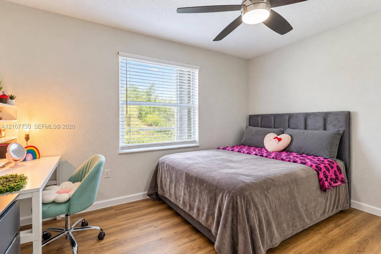 15606 SW 52nd Court, Miramar, FL 33027 Room featuring wood-finish flooring, a neutral color palette, a large window with horizontal blinds, and a contemporary ceiling fan with integrated lighting