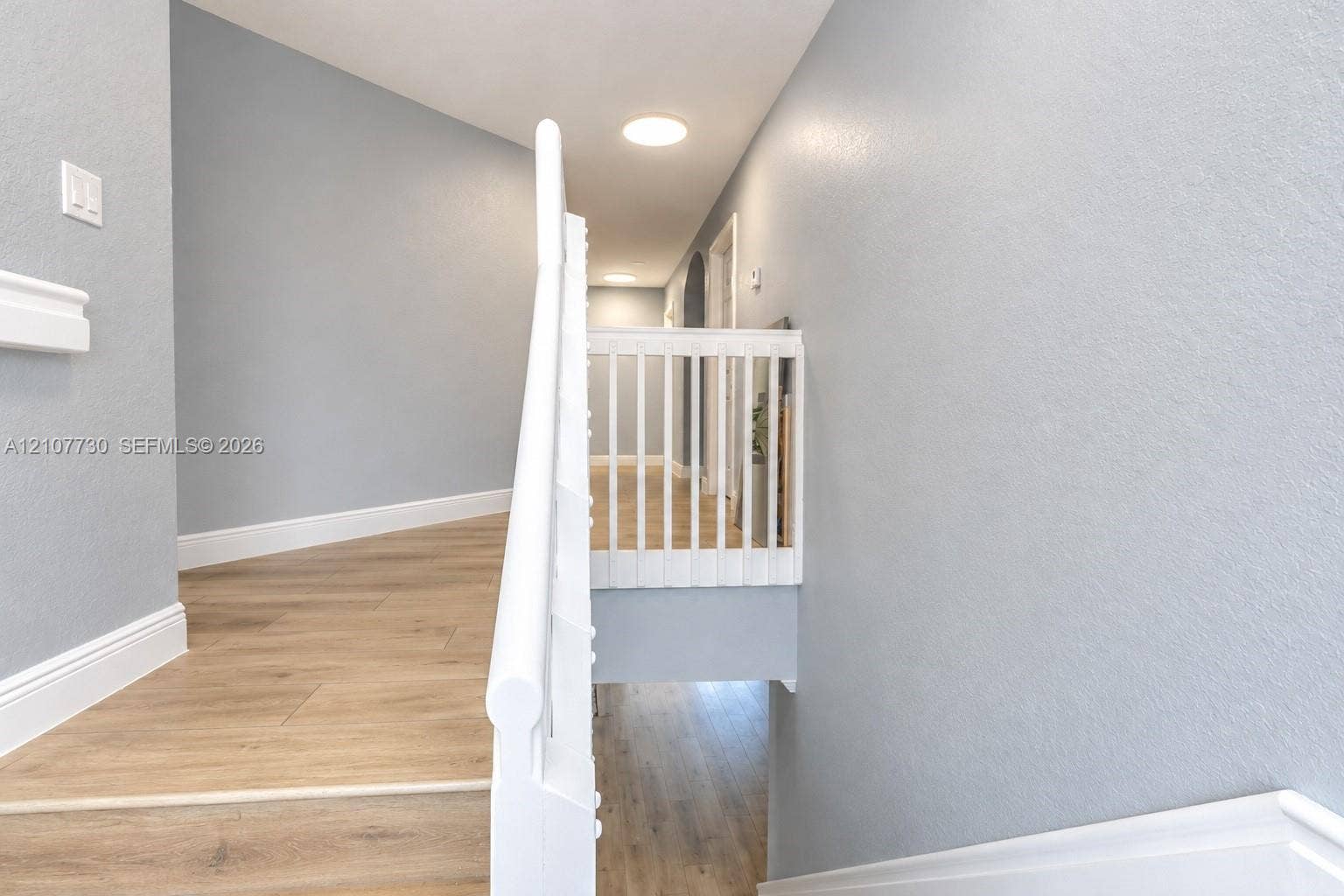 15606 SW 52nd Court, Miramar, FL 33027 Hallway featuring wood-finish flooring, white spindle railing, recessed ceiling lighting, and neutral wall paint