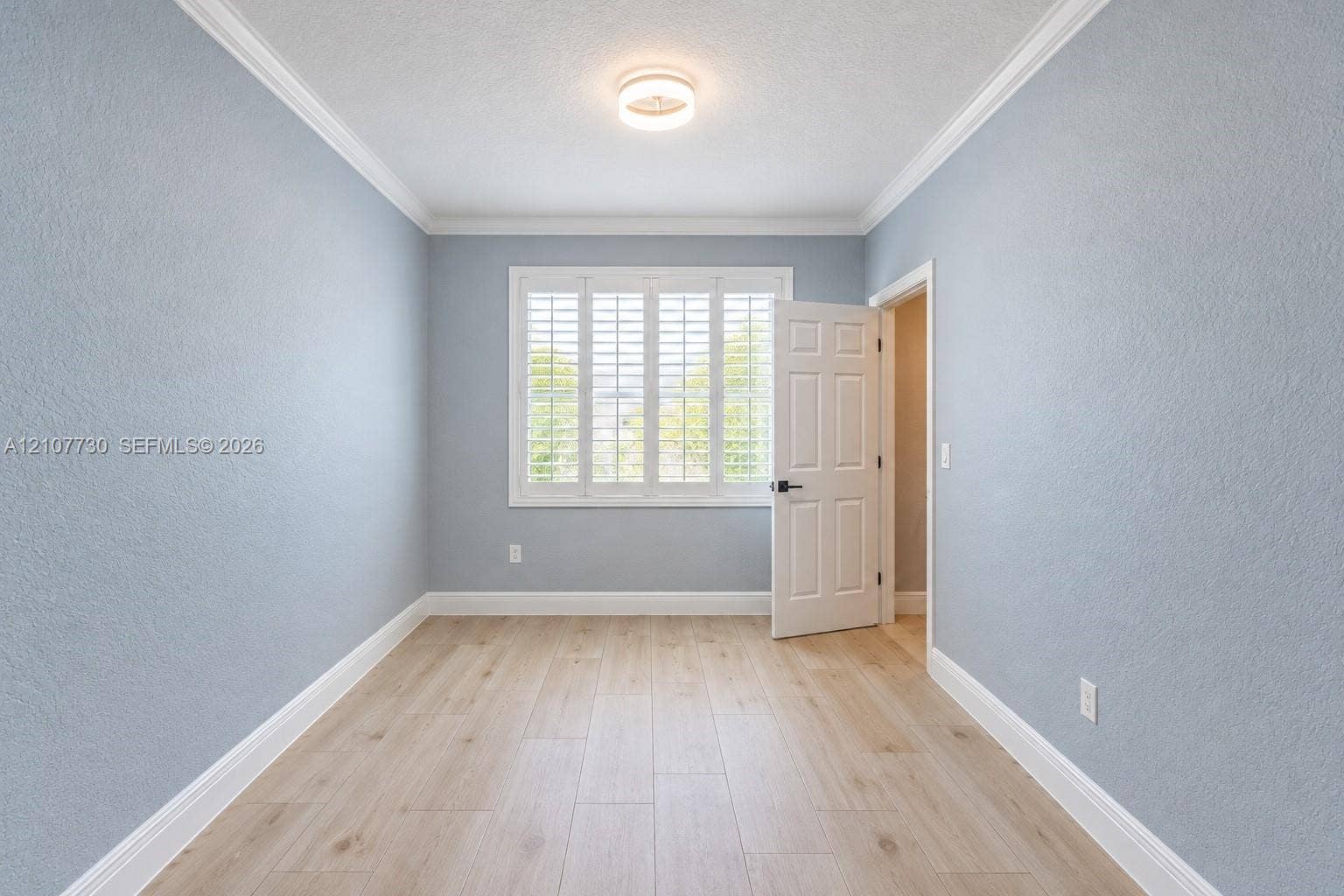 15606 SW 52nd Court, Miramar, FL 33027 Light-filled interior featuring wood-finish flooring, plantation shutters, crown molding, and a neutral color palette