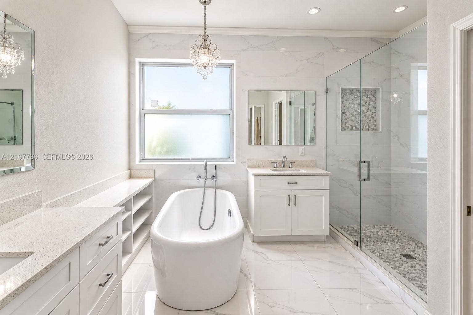 15606 SW 52nd Court, Miramar, FL 33027 Bathroom featuring a freestanding soaking tub, walk-in glass-enclosed shower with a stone-tile floor, dual white vanities with solid-surface countertops, and decorative pendant lighting