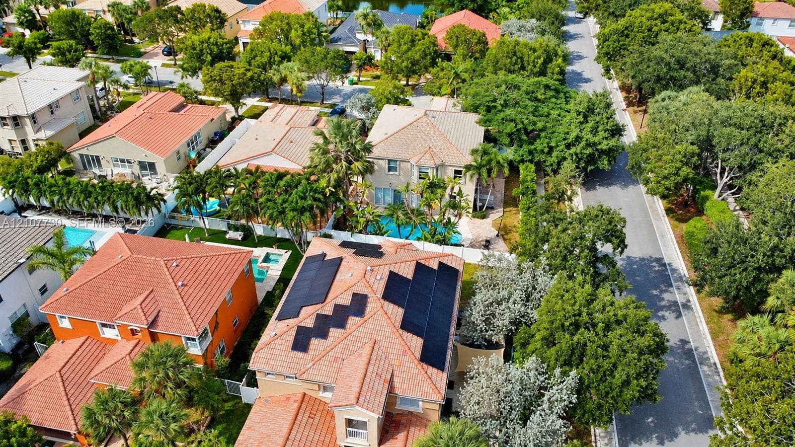 15606 SW 52nd Court, Miramar, FL 33027 Aerial perspective featuring tile roofing, roof-mounted solar panels, private swimming pools, and mature landscaping