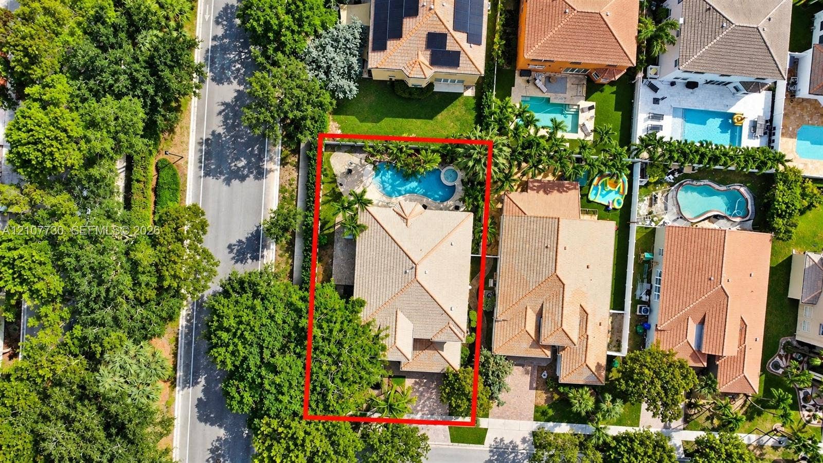 15606 SW 52nd Court, Miramar, FL 33027 Aerial perspective of a property featuring a tiled roof, an inground swimming pool with a spa, and a paved driveway