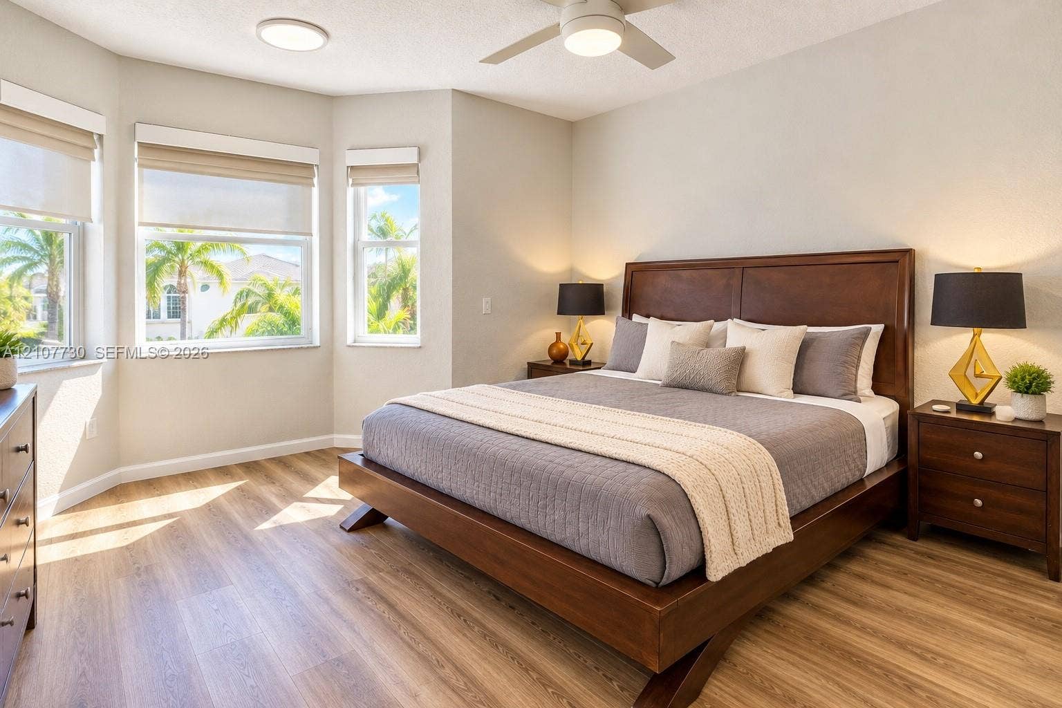 15606 SW 52nd Court, Miramar, FL 33027 Bay window featuring three large windows, wood-finish flooring, and a white ceiling fan with integrated lighting