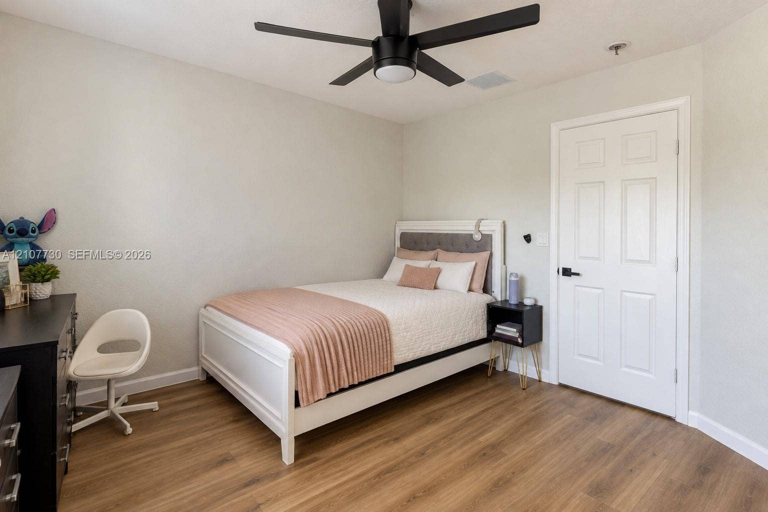 15606 SW 52nd Court, Miramar, FL 33027 Room featuring wood-finish flooring, a matte black ceiling fan with integrated lighting, and a six-panel door with matte black hardware