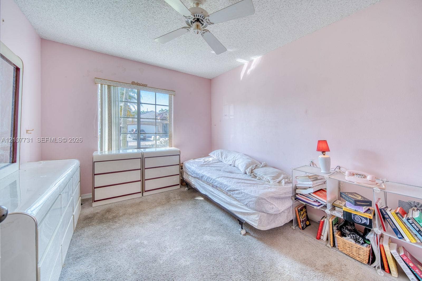 Bedroom featuring a ceiling fan, wall-to-wall carpeting, and a multi-pane window with vertical blinds