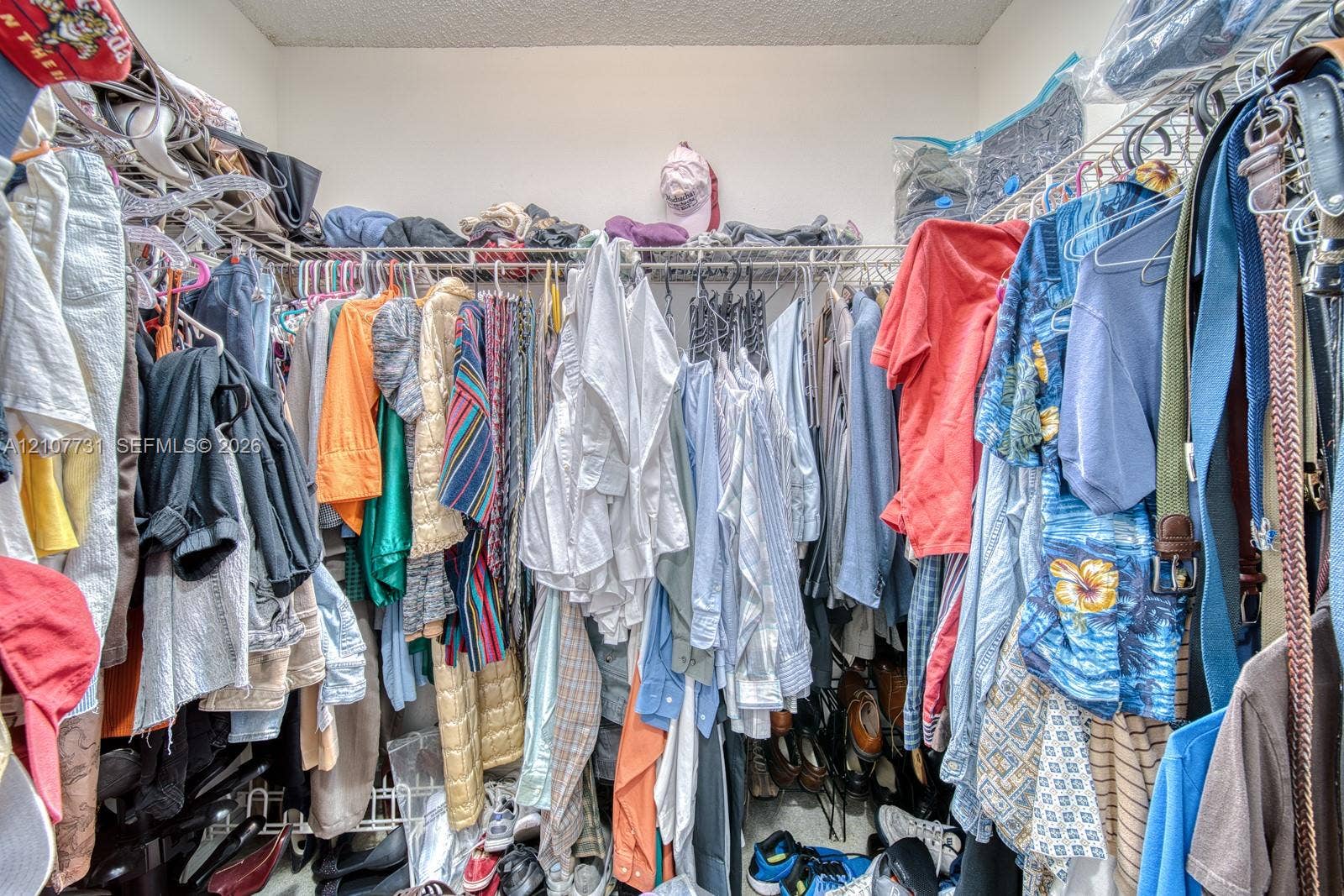 Walk-in closet featuring multi-tiered wire shelving and integrated hanging rods